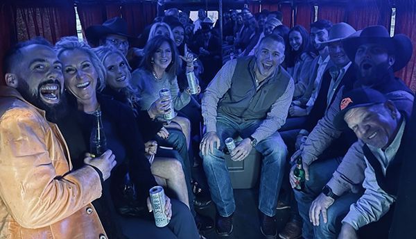 A group of people are sitting on a bus enjoying Wedding Party.