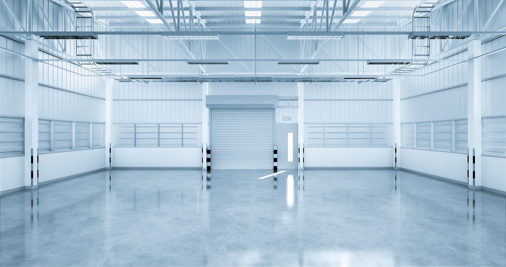 Closed steel roll-up garage door inside a bright, empty industrial warehouse interior