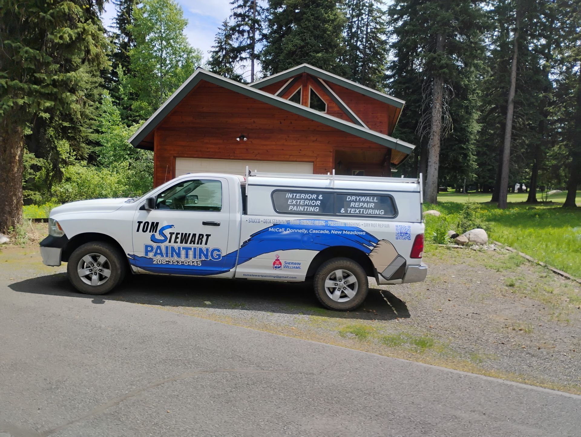 White service van parked by a red cabin in a wooded area, with “Star Painting” logo on the side.