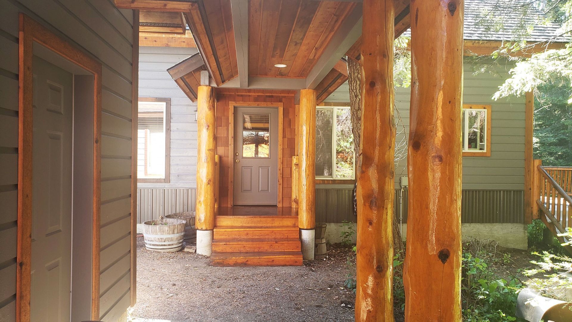 Wooden front porch with rustic posts and a centered front door under a covered entryway