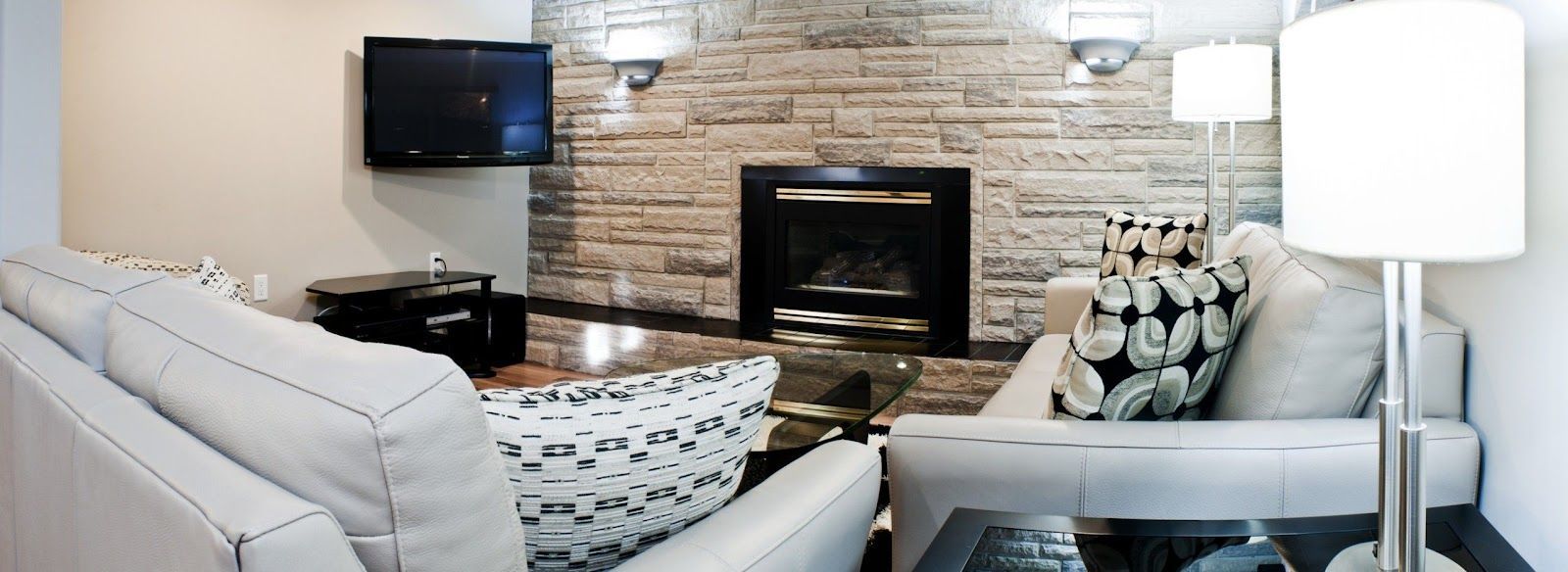 A living room with white furniture and a fireplace