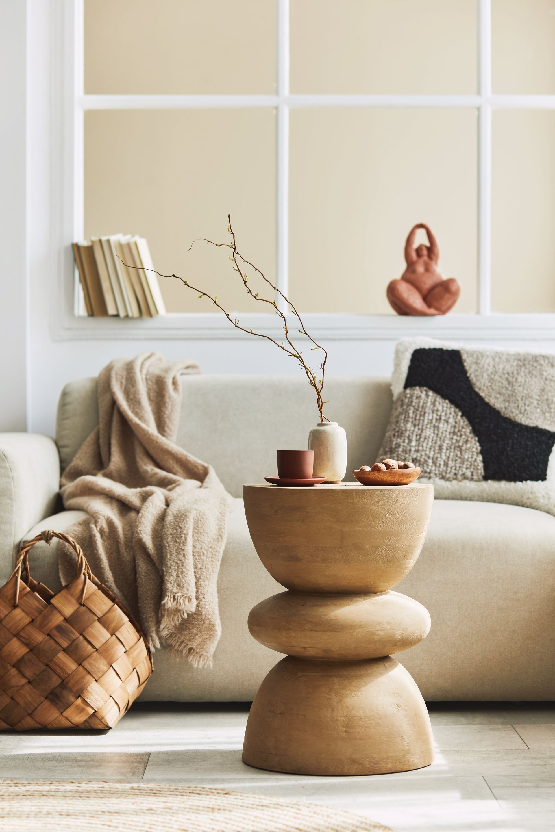 A living room with a couch and a table with a vase on it.