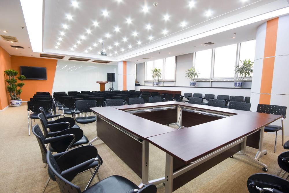 A large conference room with a long table and chairs