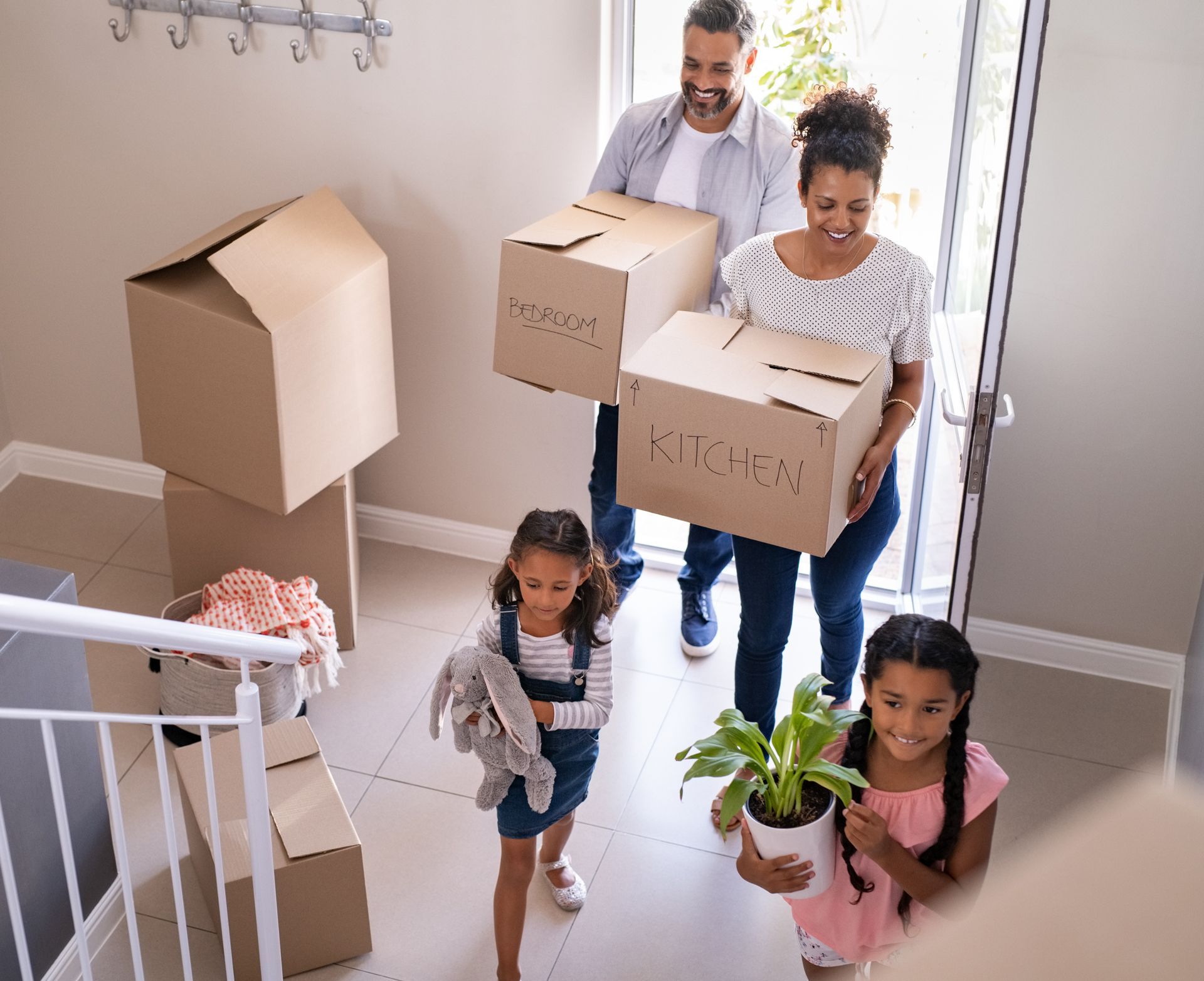 a family is carrying boxes into their new home