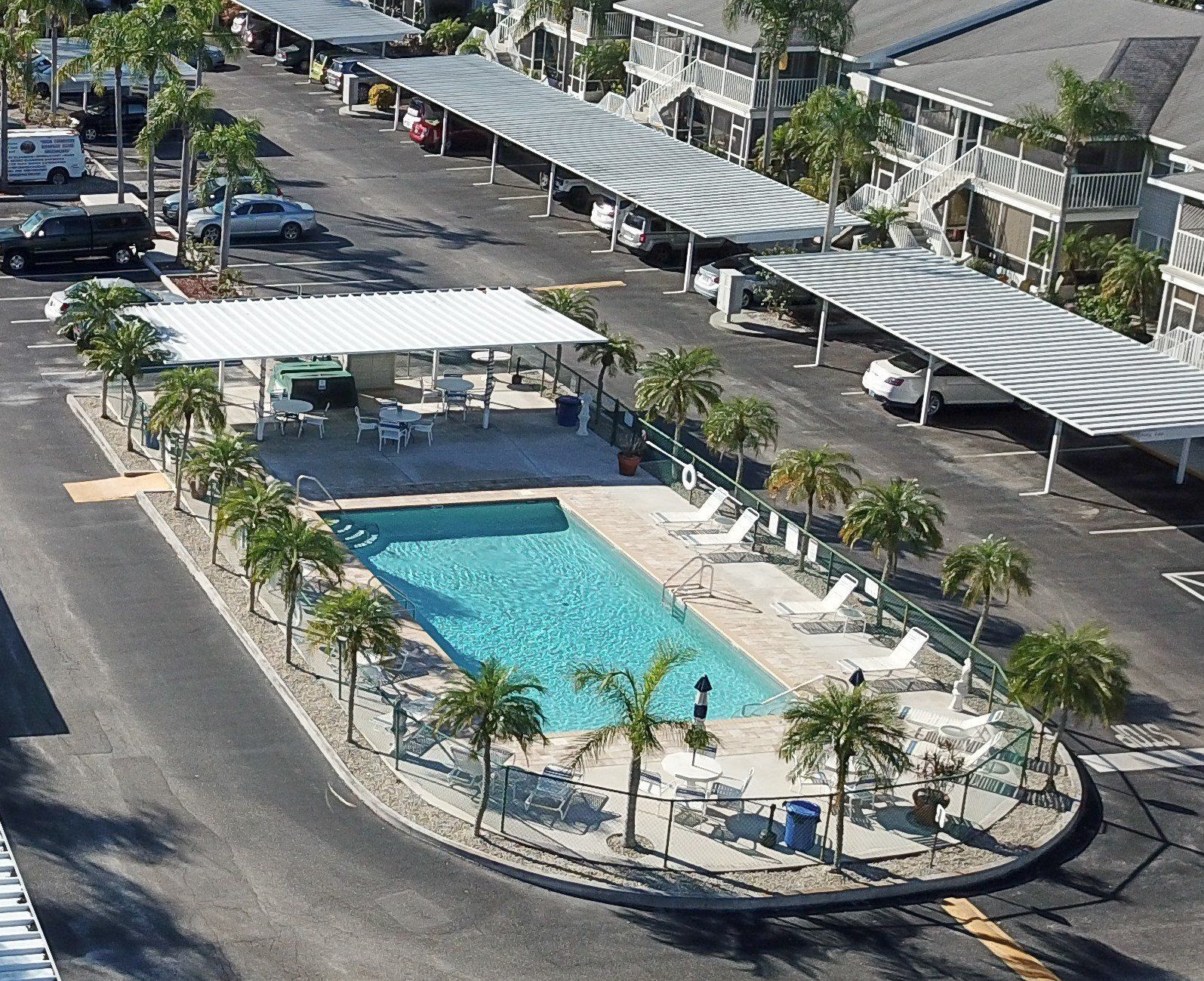 An Aerial View Of A Swimming Pool Surrounded By Palm Trees