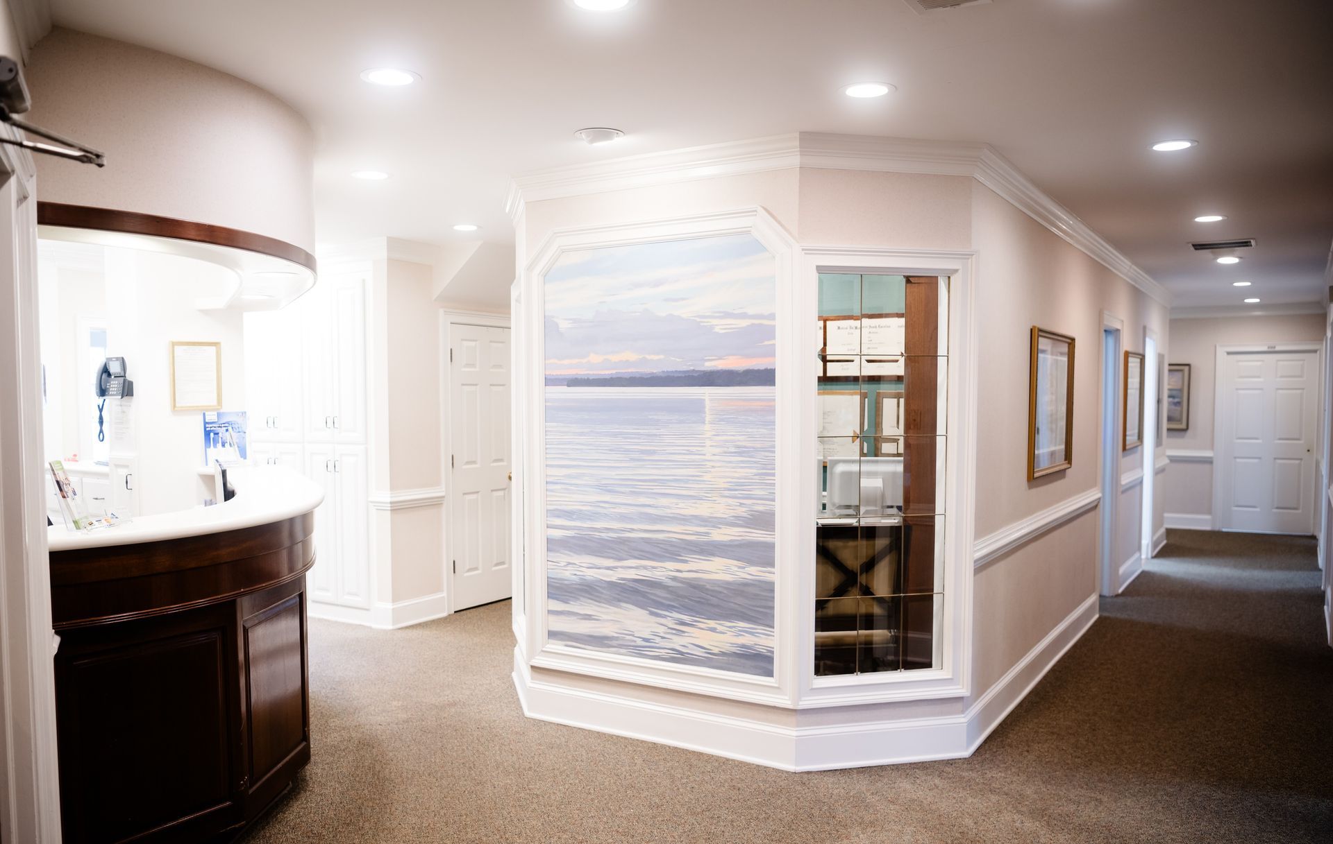 Bright hallway with beach mural, recessed lights, and white trim in a modern interior