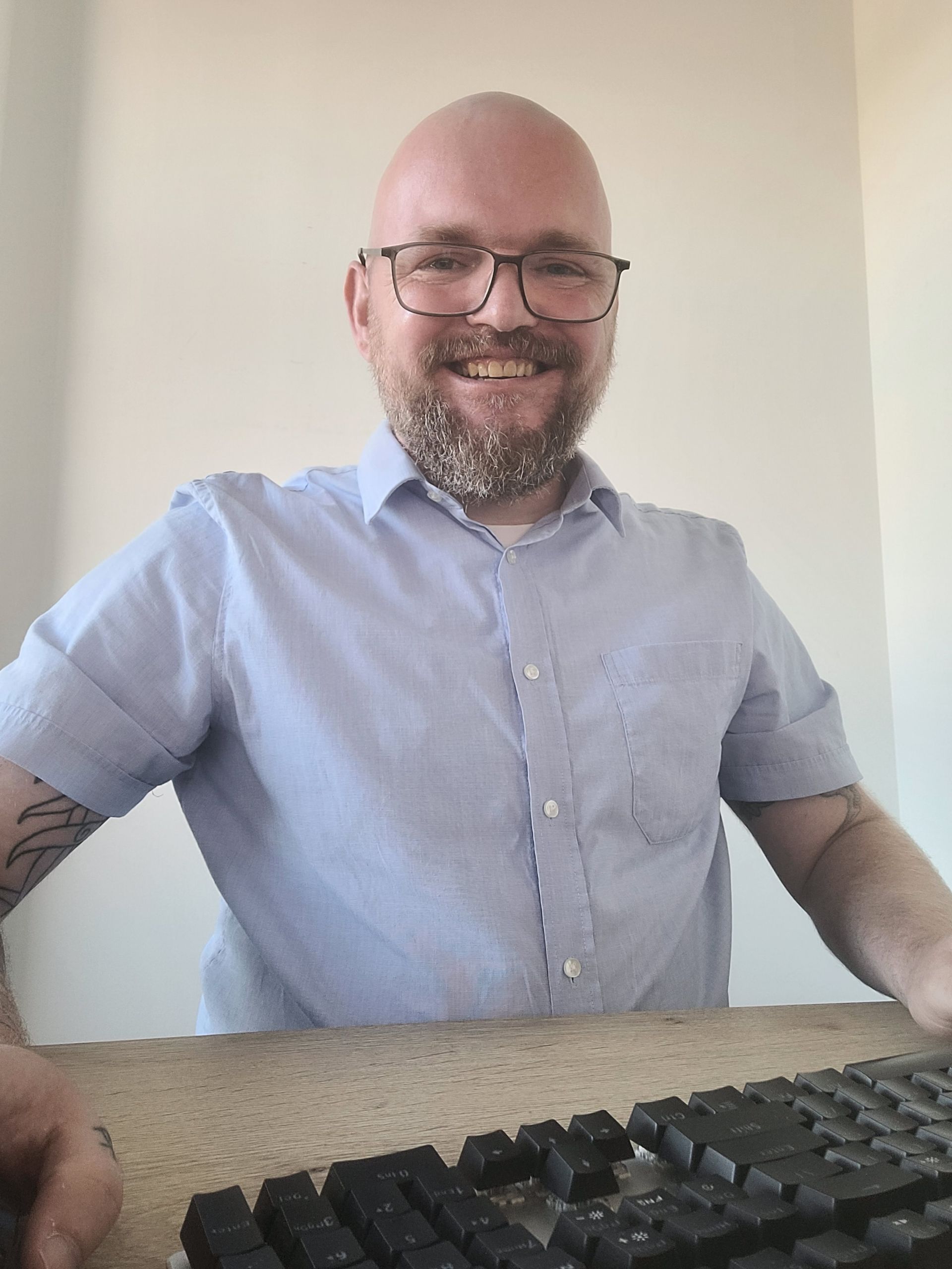 Trystan Nieuwenhuis achter laptop, lachend naar camera.