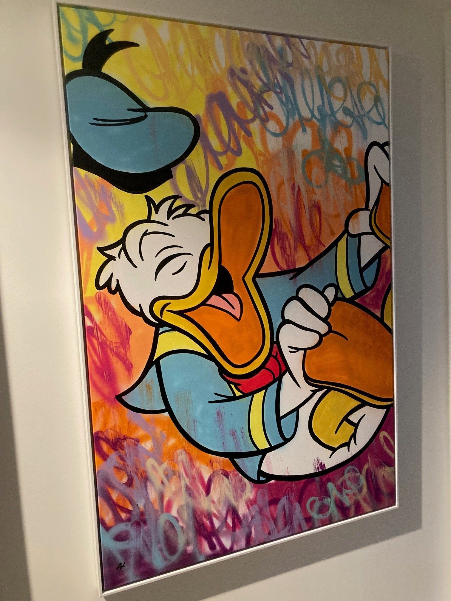 Cartoontekening van Donald Duck, lachend, ingelijst. Kleurrijke achtergrond met een handgeschreven tekst.