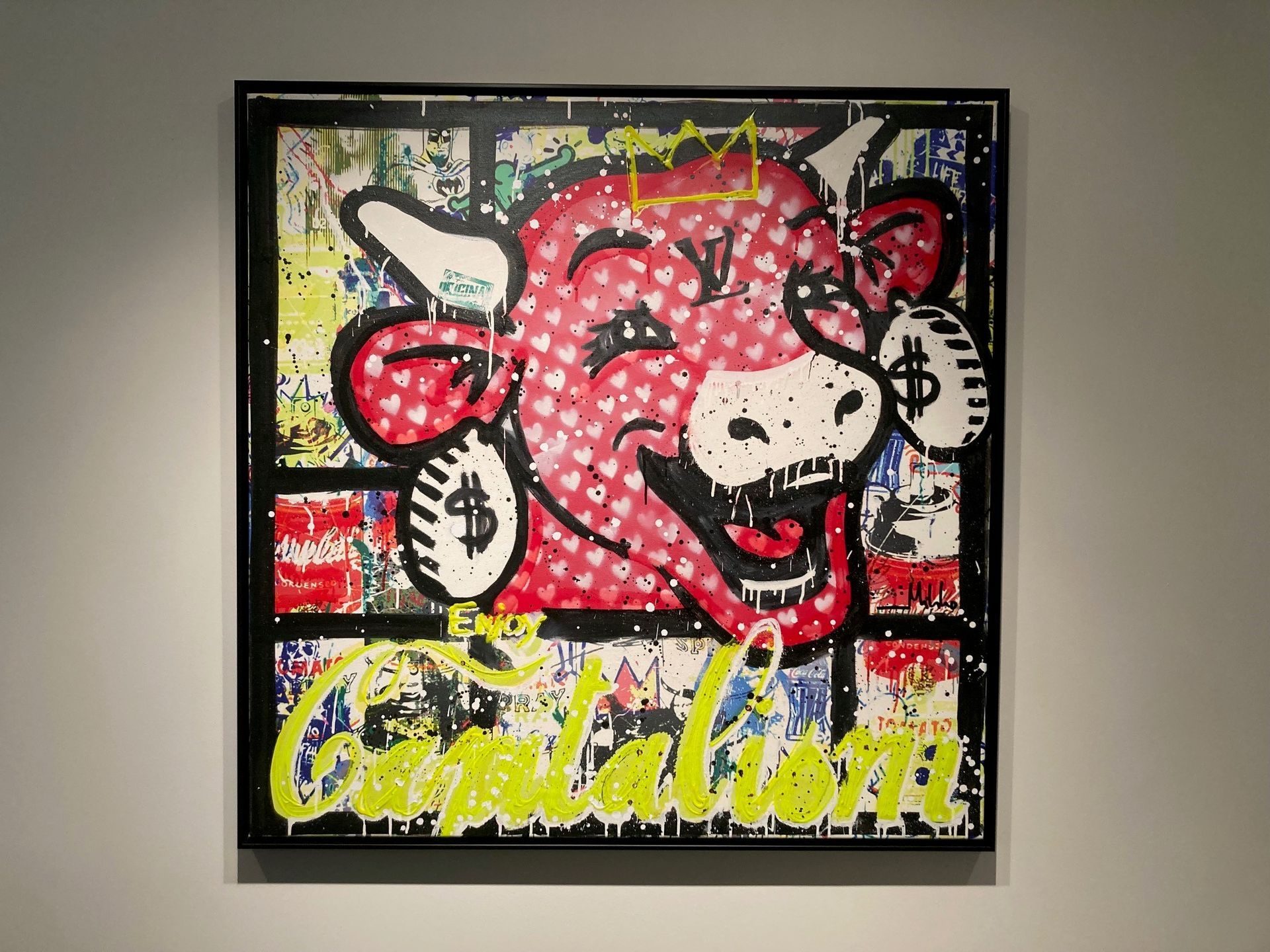 Popartschilderij van een lachende rode koe met oorbellen in de vorm van een dollarteken, met het opschrift "Kapitalisme".
