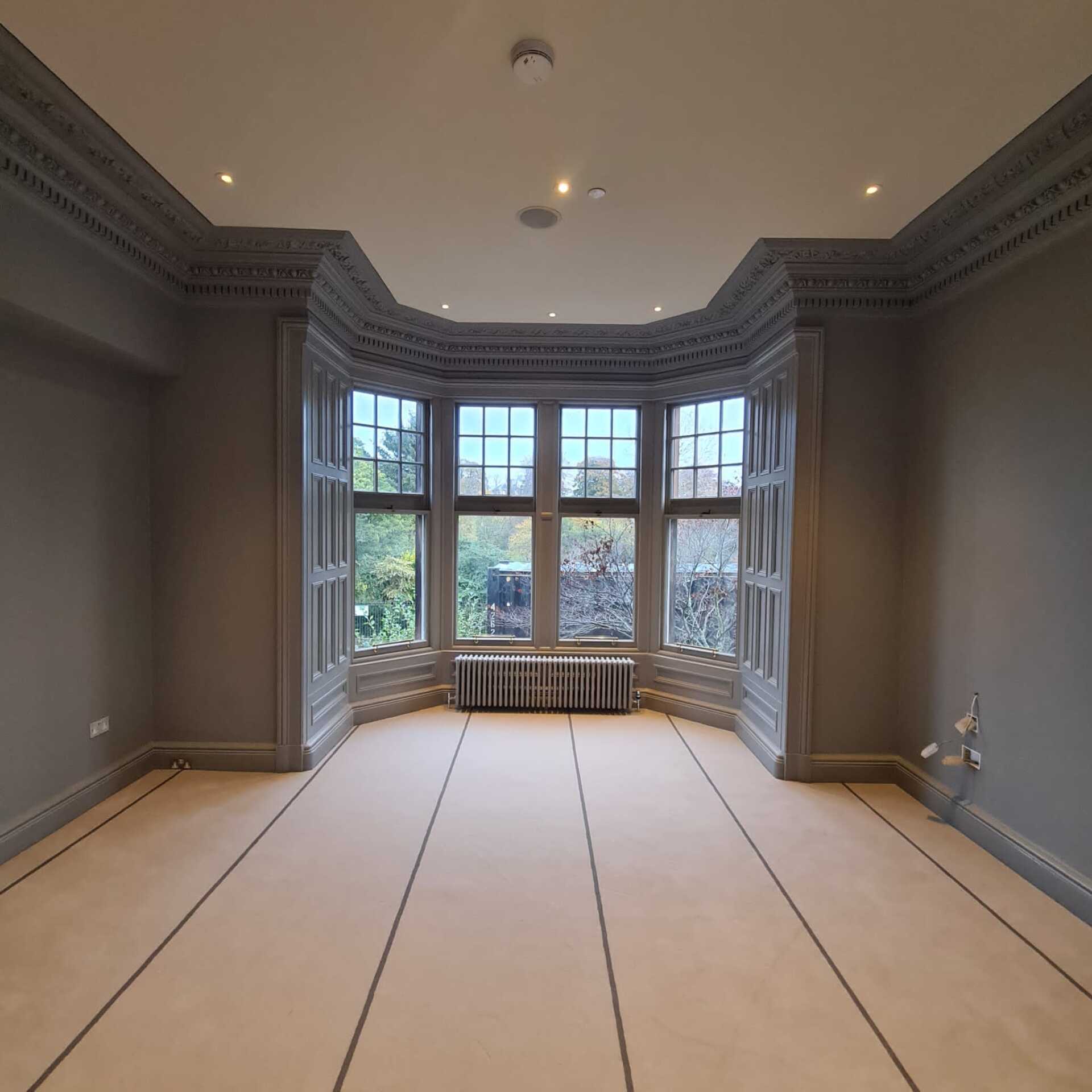 An empty room with a large bay window