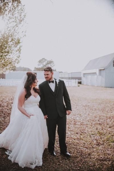 Bride and groom in formal wear standing together outdoors at a wedding venue