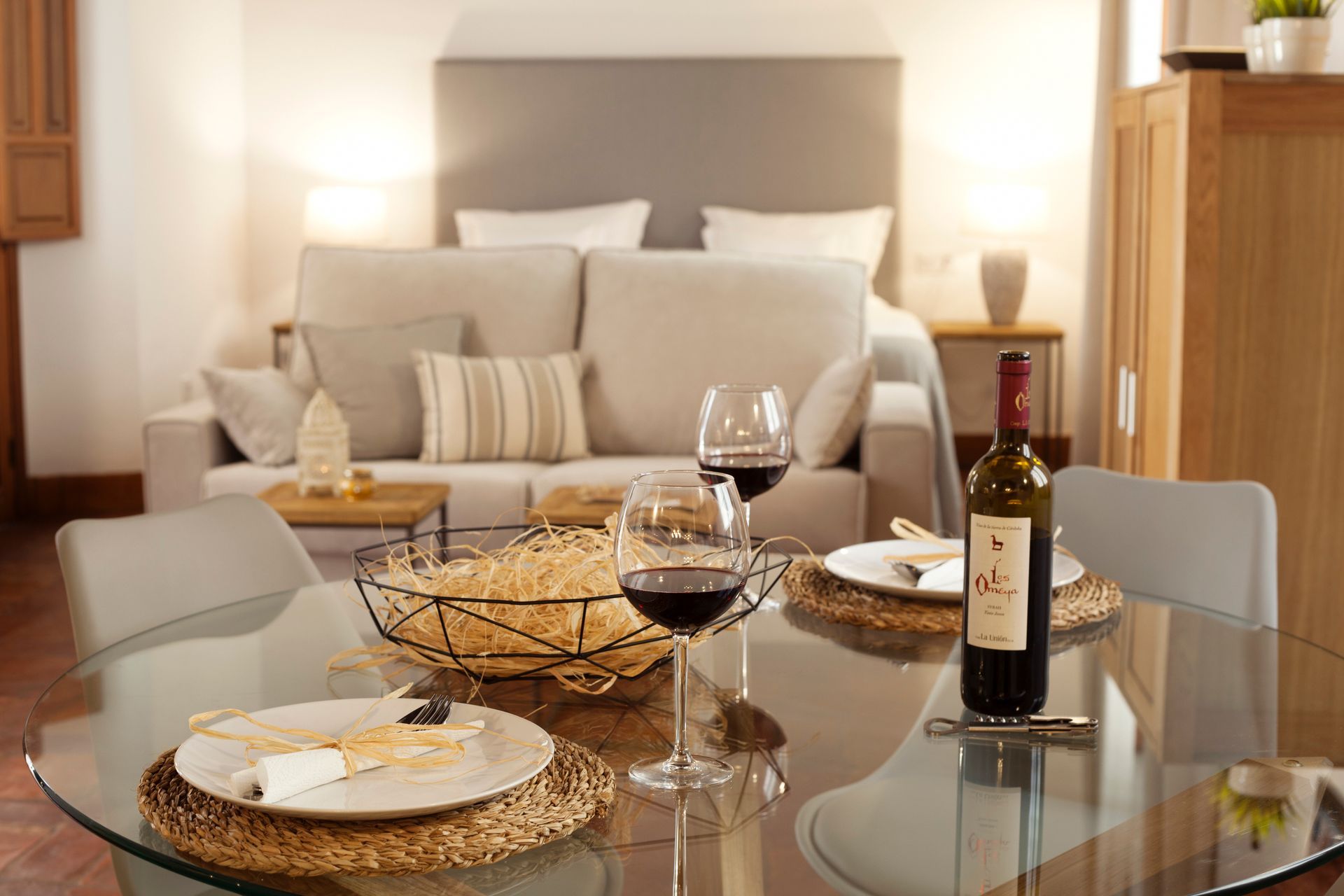 Elegant dining table set before a cozy beige sofa in a softly lit living room.