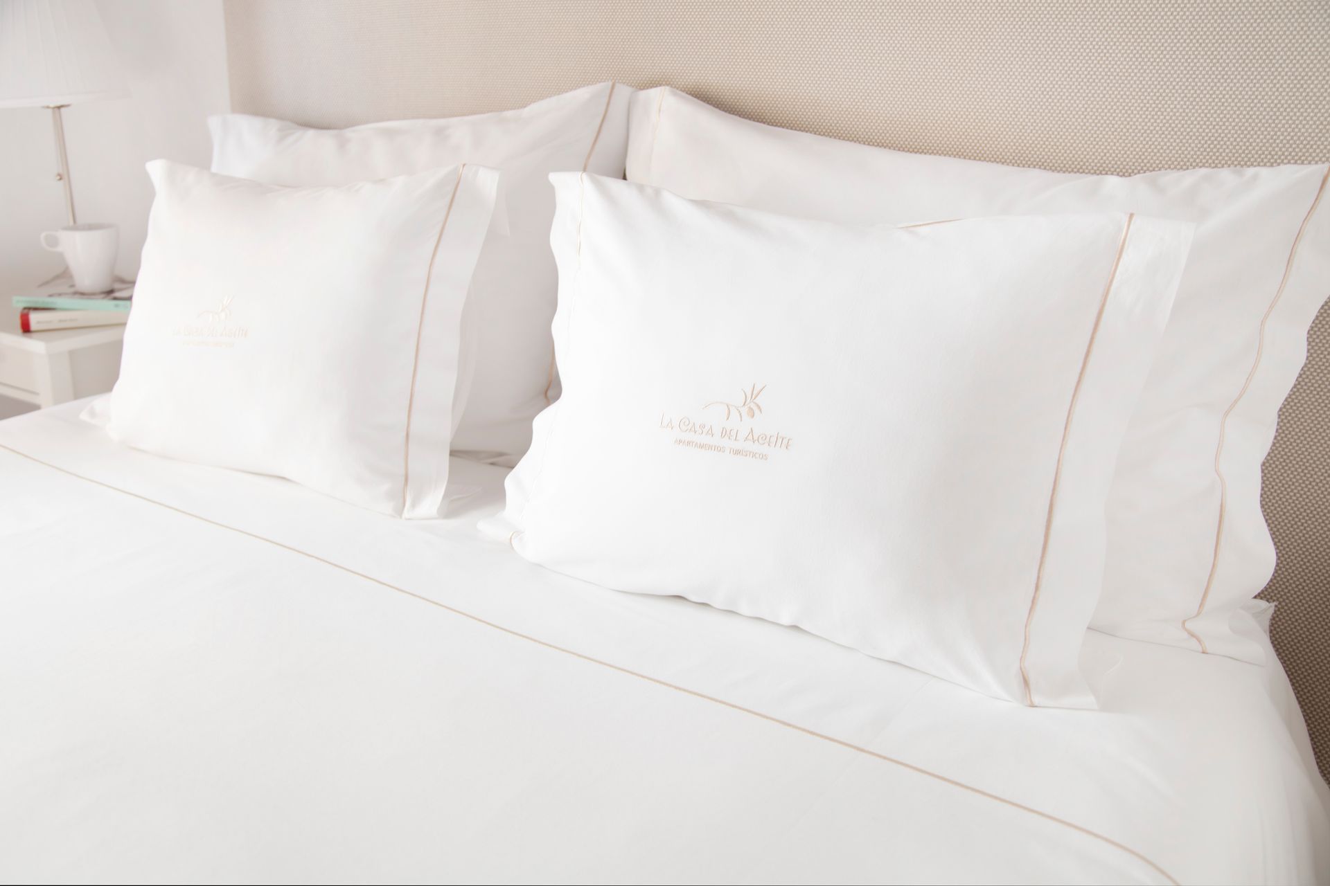 White bed with neatly arranged pillows and white bedding in a bright bedroom