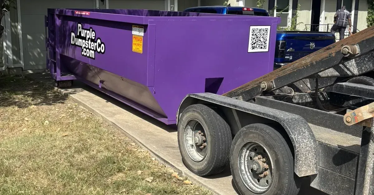 Purple Dumpster Co dumpster delivery in driveway