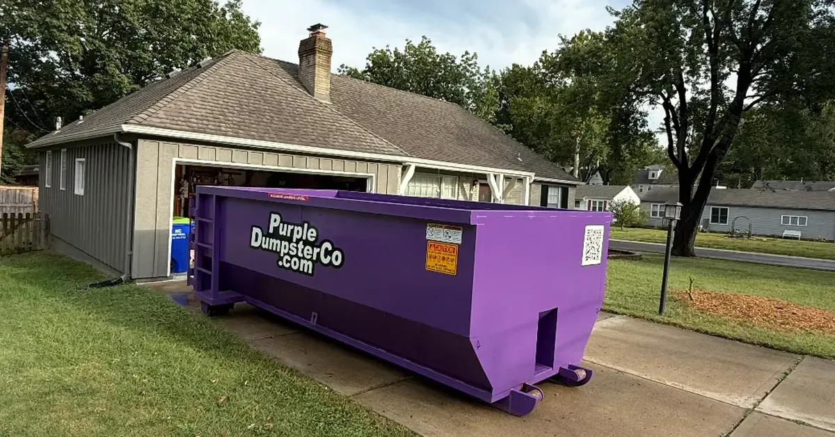 Purple Dumpster Co dumpster rental in driveway