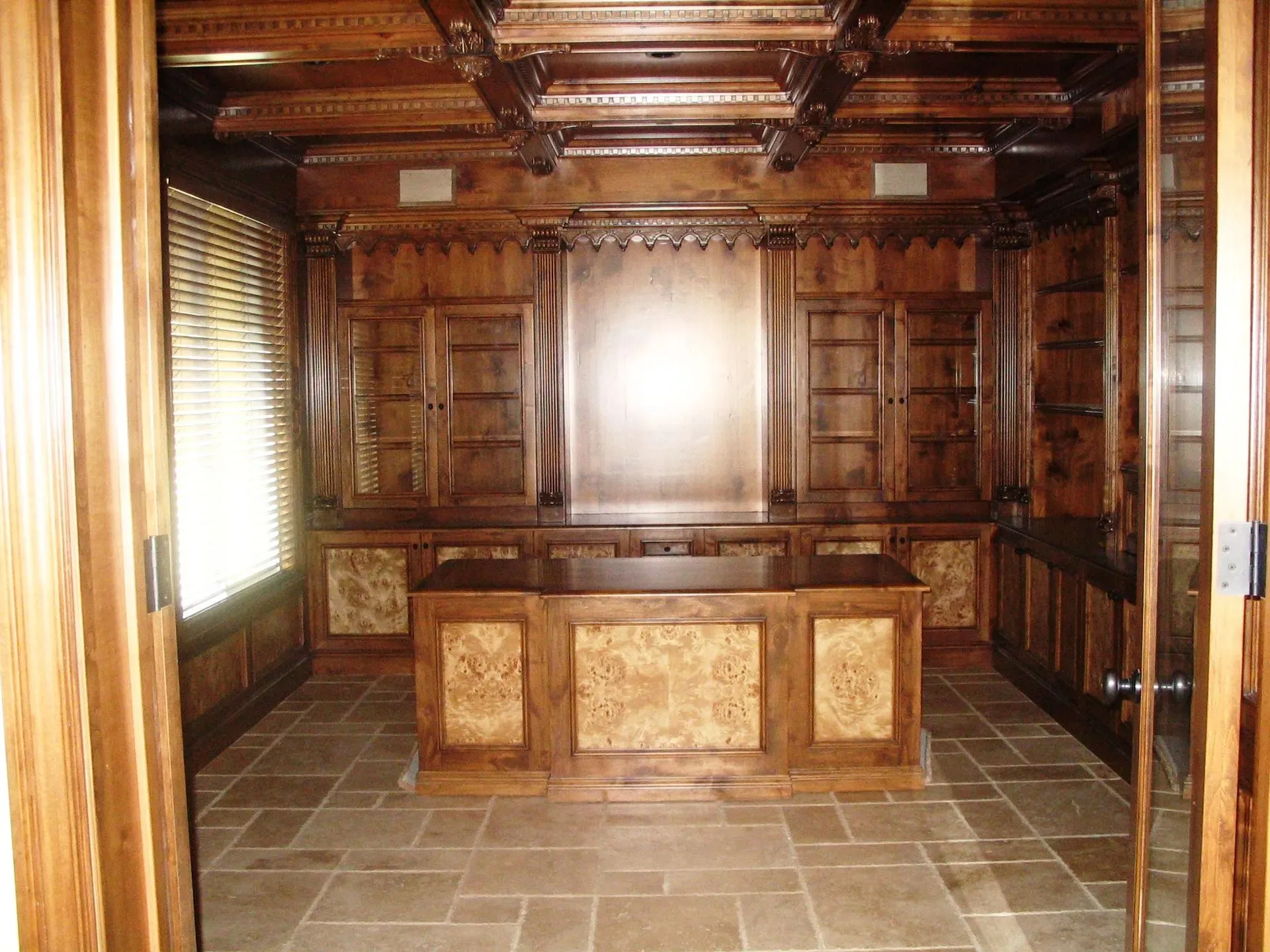 Wood-paneled room with tiled floor, built-in desk, and bright window light