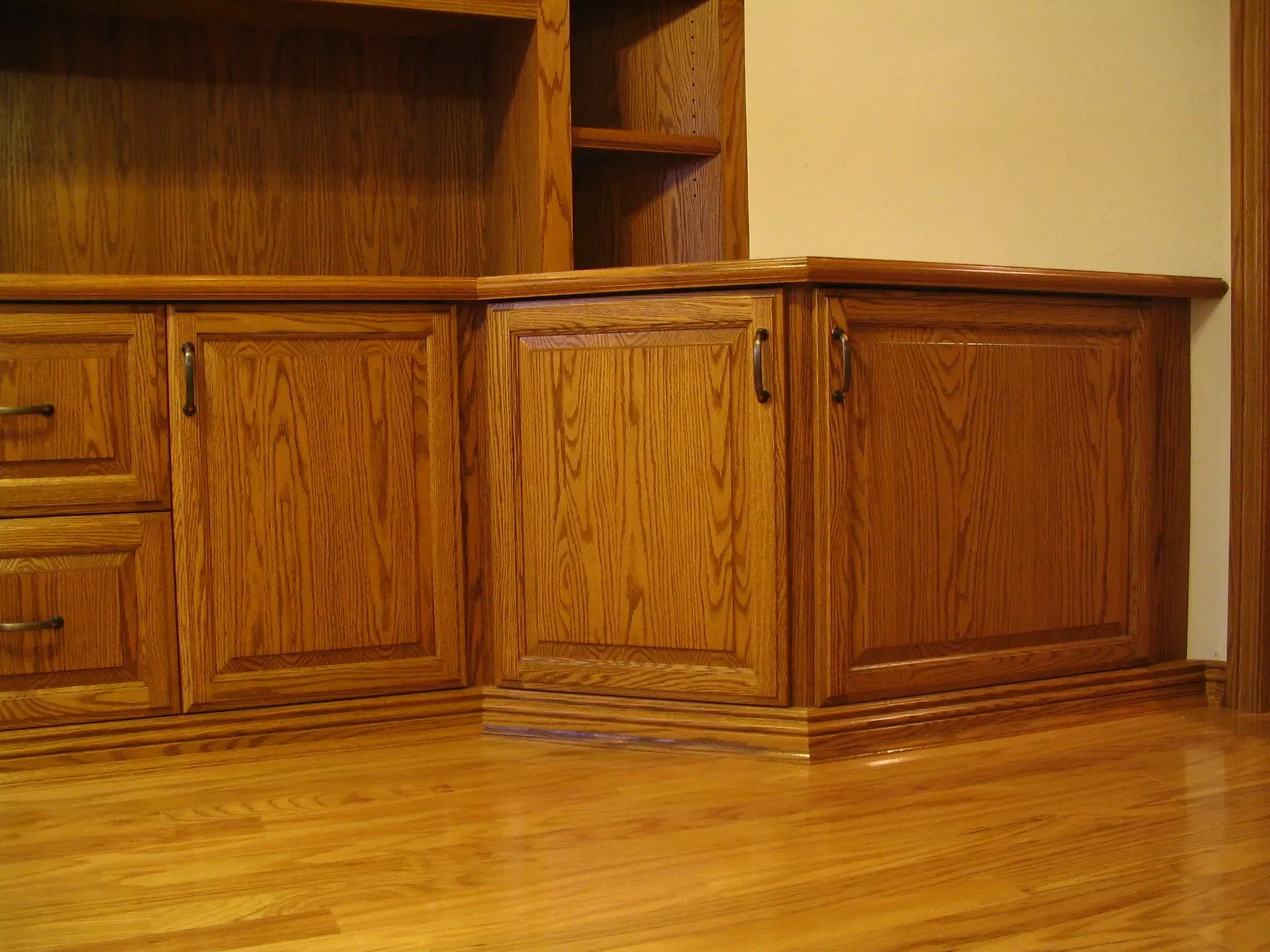 Wooden built-in cabinets and shelving beside a polished hardwood floor