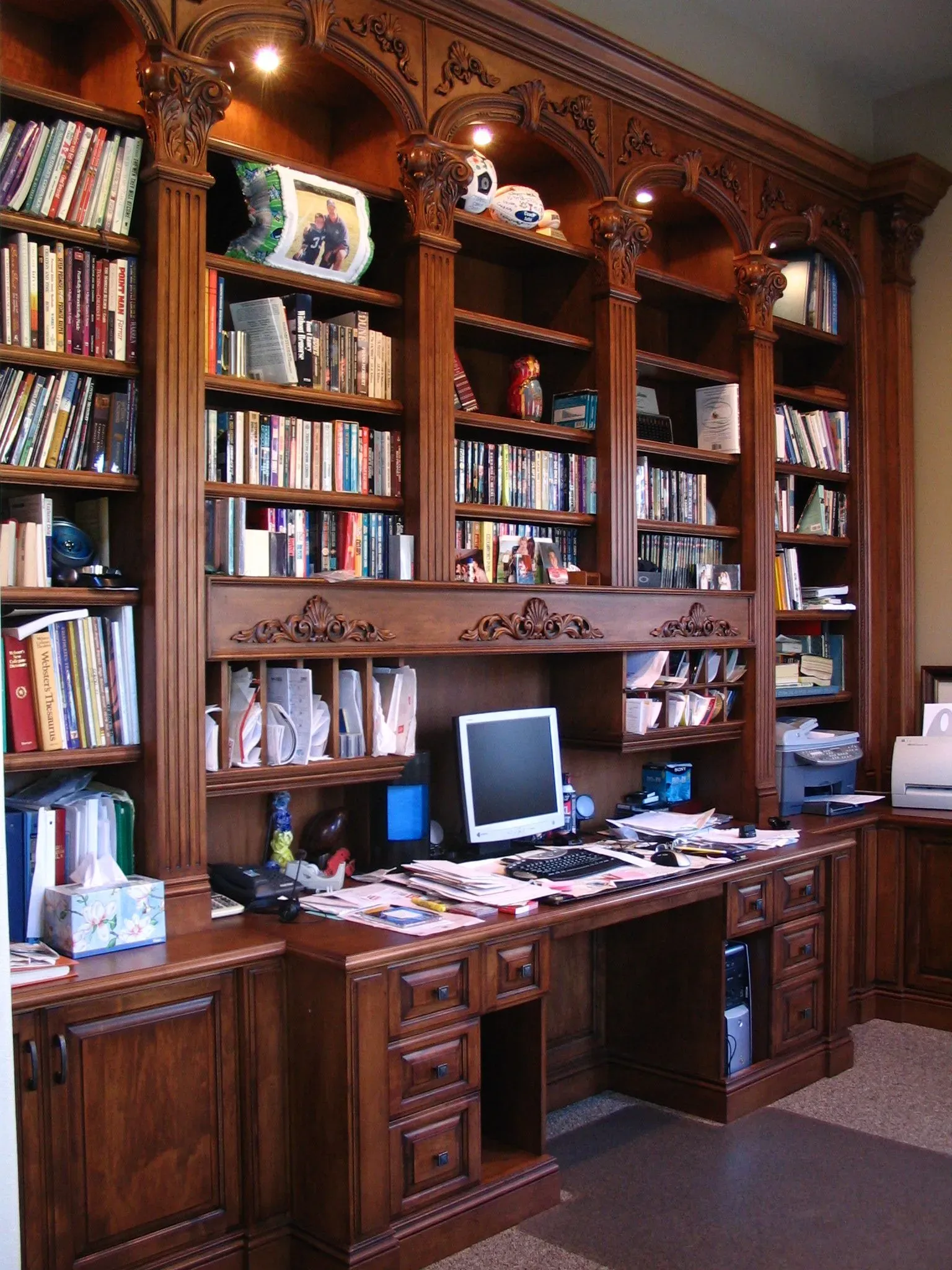 Wooden home office with built-in bookshelves, desk, and computer monitor