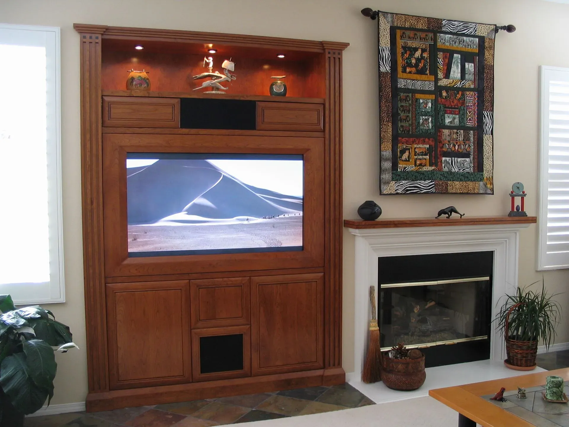 Living room with a large wooden entertainment center displaying a mountain scene and a white fireplace beside it
