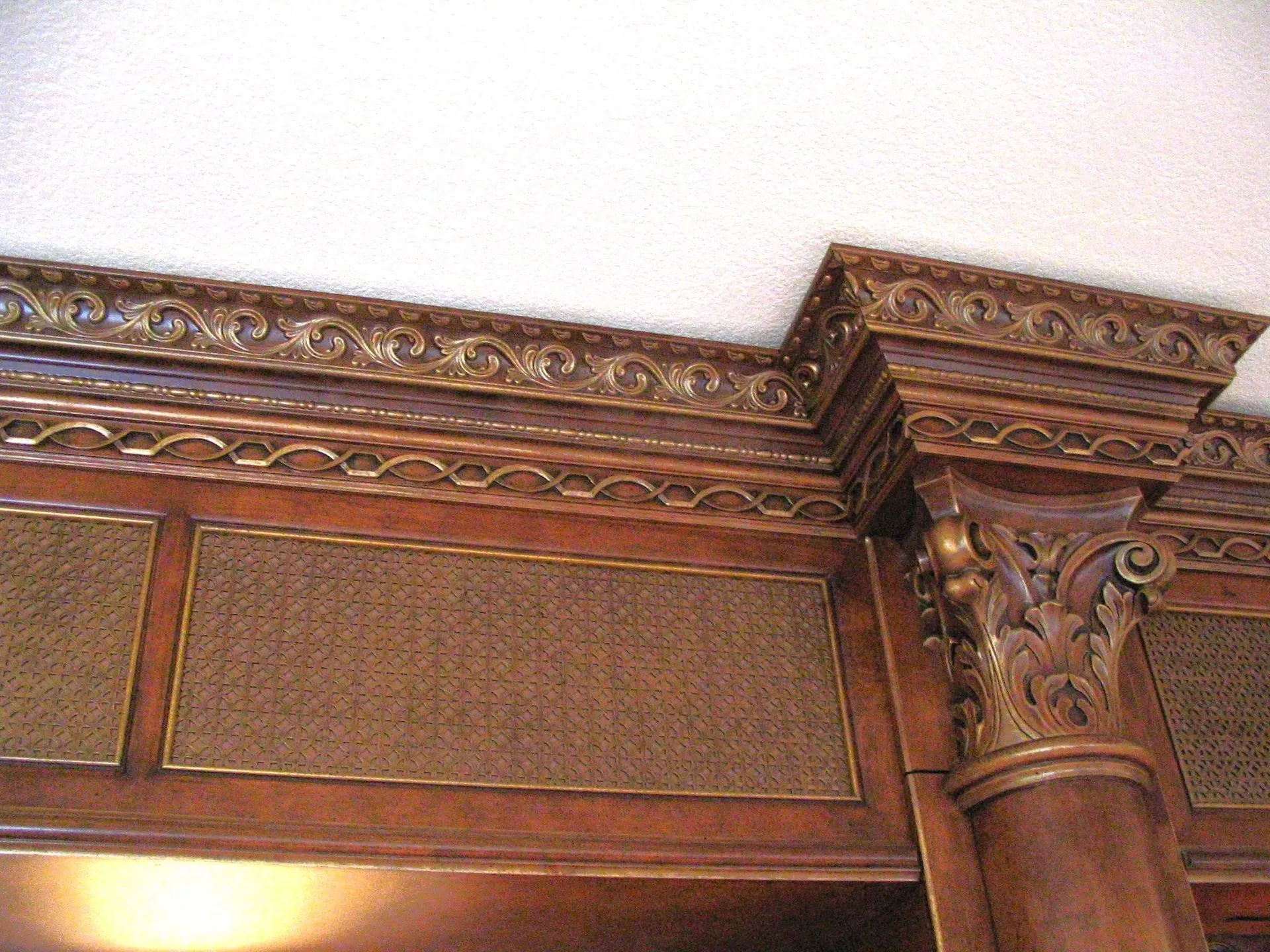 Ornate carved wooden interior molding and column with decorative trim and panels