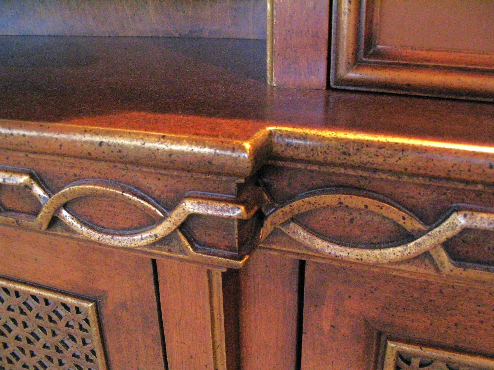 Close-up of a wooden cabinet with carved decorative trim and polished brown finish