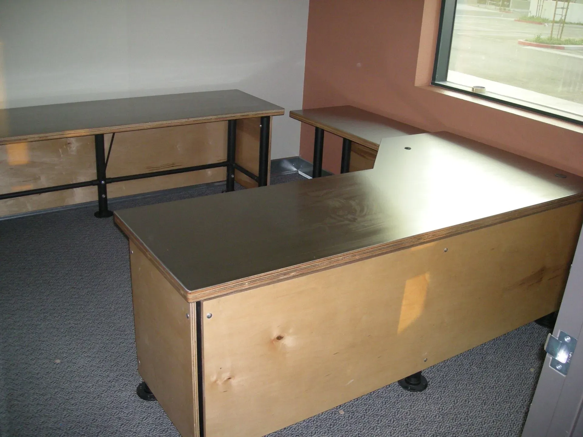 Empty classroom with two desks and carpeted floor near a window