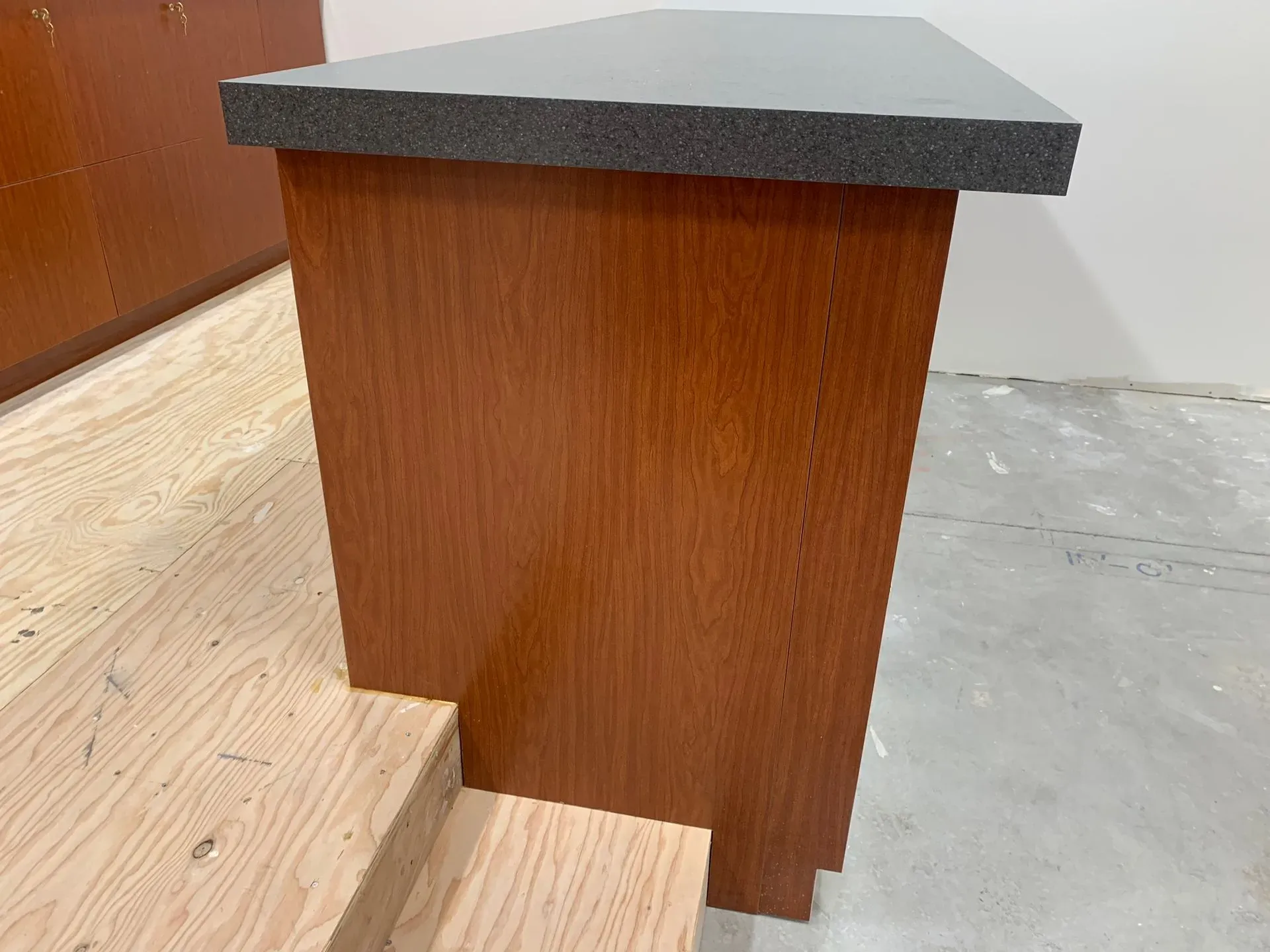 Wooden lectern or podium with a dark top in a room with light wood flooring