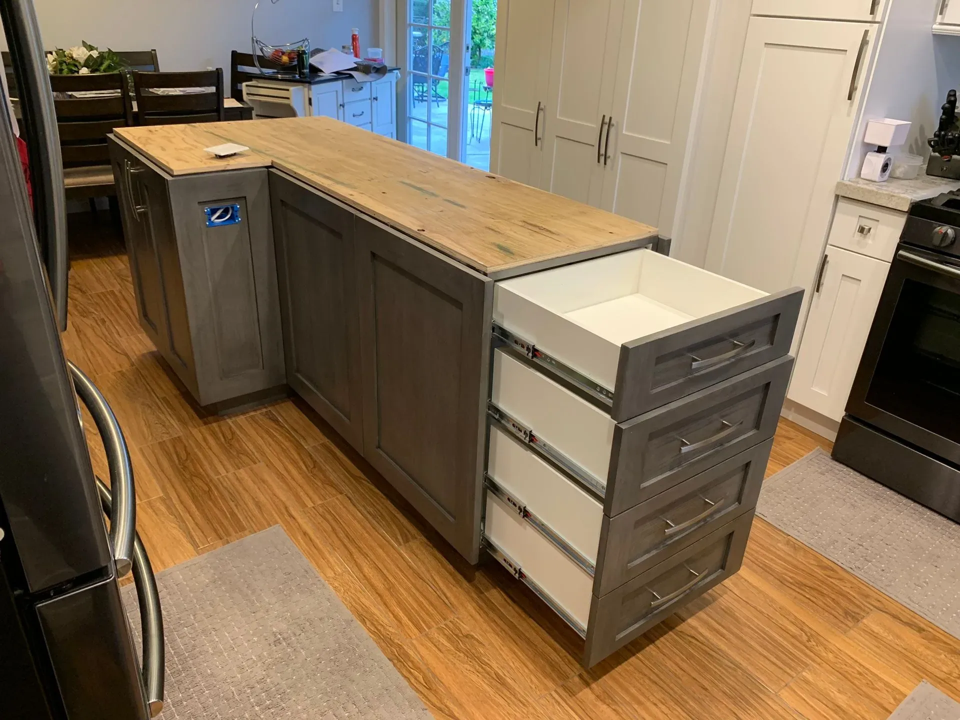 Kitchen island with wood countertop and gray drawers on a hardwood floor