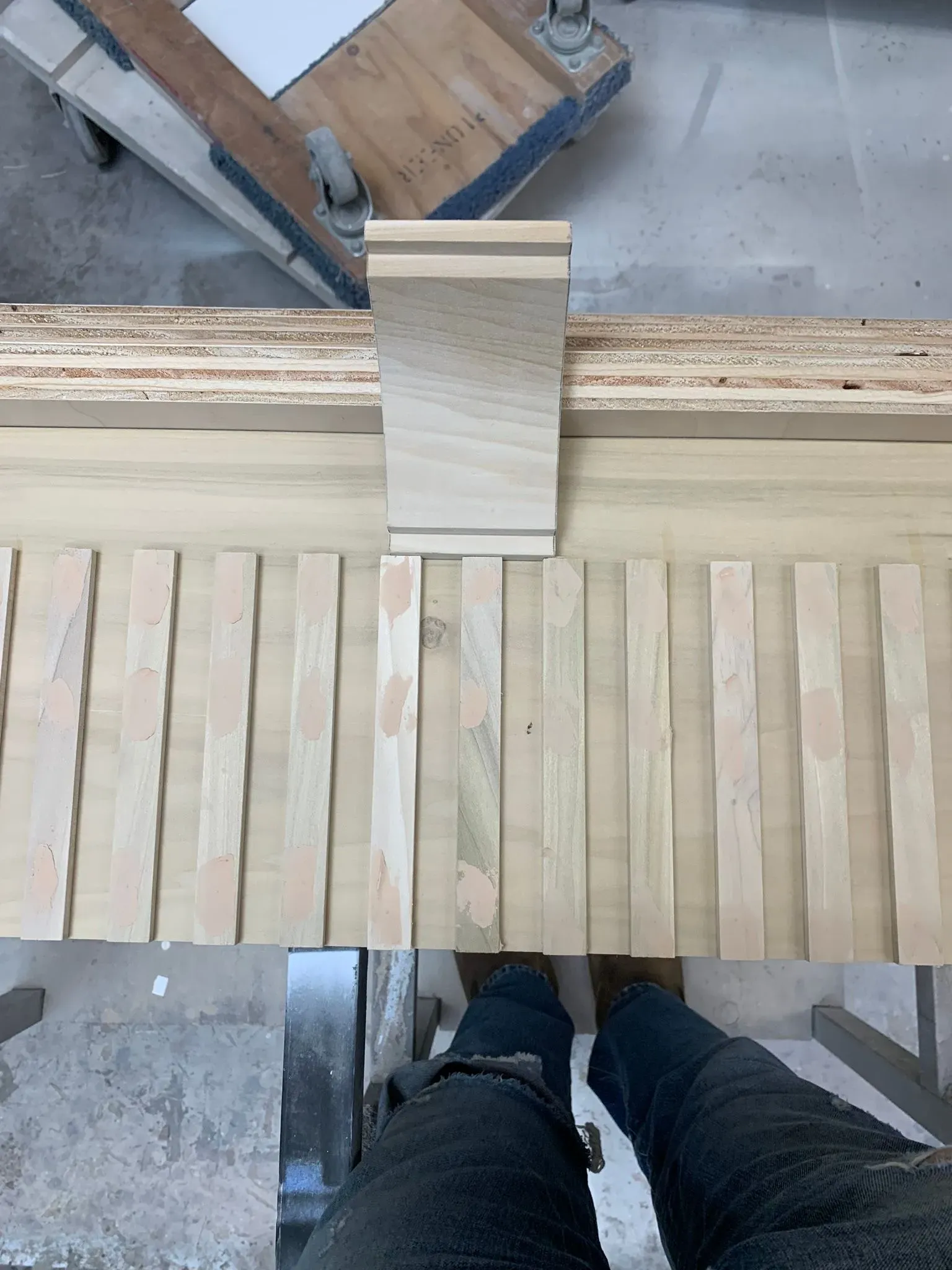 Wooden slatted walkway with a central ramp section and a person’s shoes visible at the bottom edge