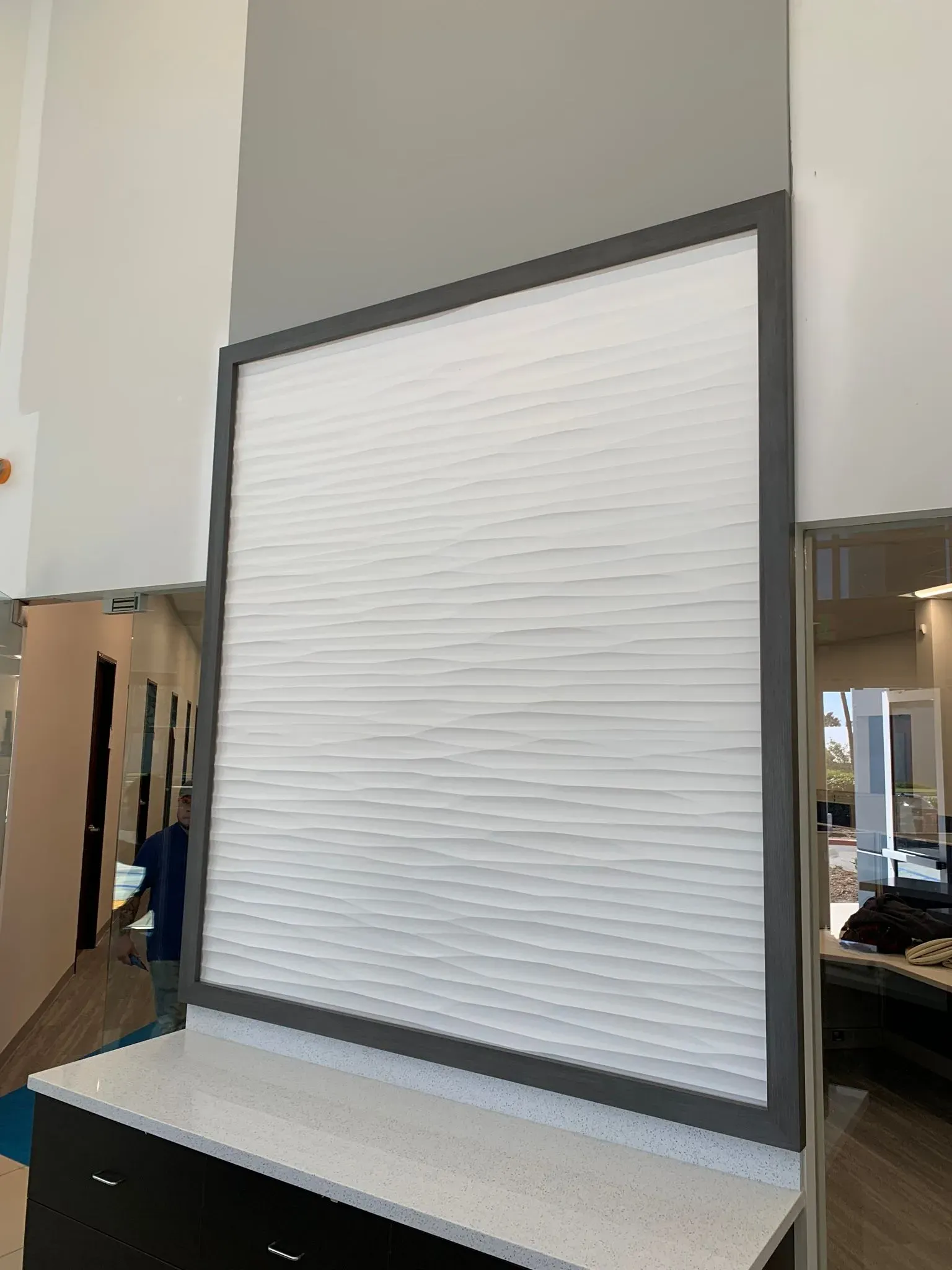 Large blank white display board with a dark frame on a countertop in a room