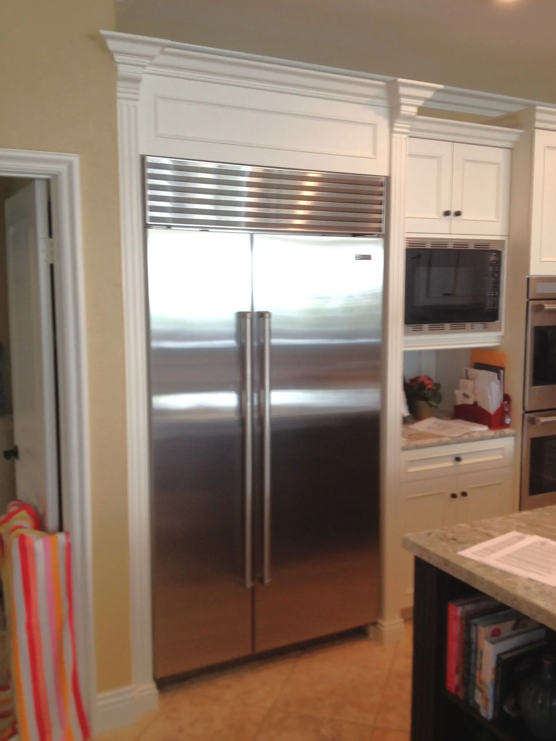 Kitchen with stainless steel French-door refrigerator and white cabinetry