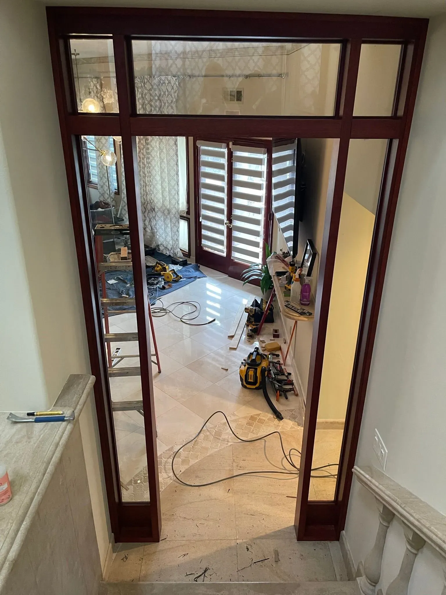 Open doorway framing a bright, unfinished room with floor debris and a bicycle inside.