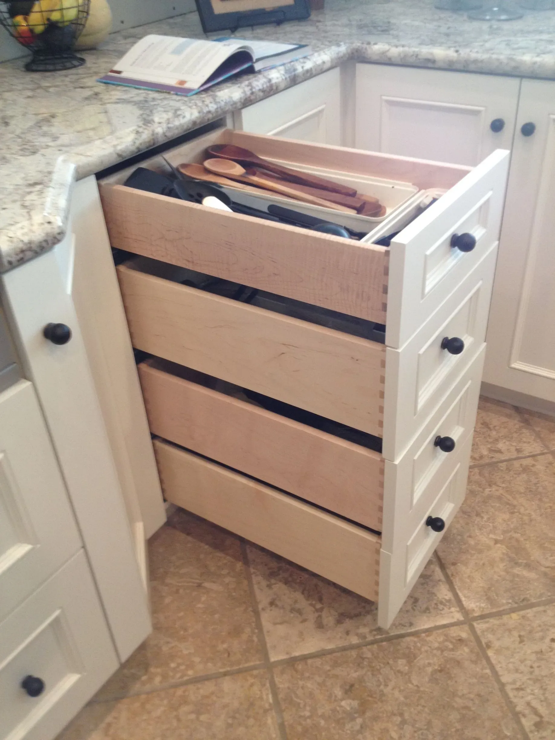 Pull-out drawer cabinet with bread storage beside a kitchen counter