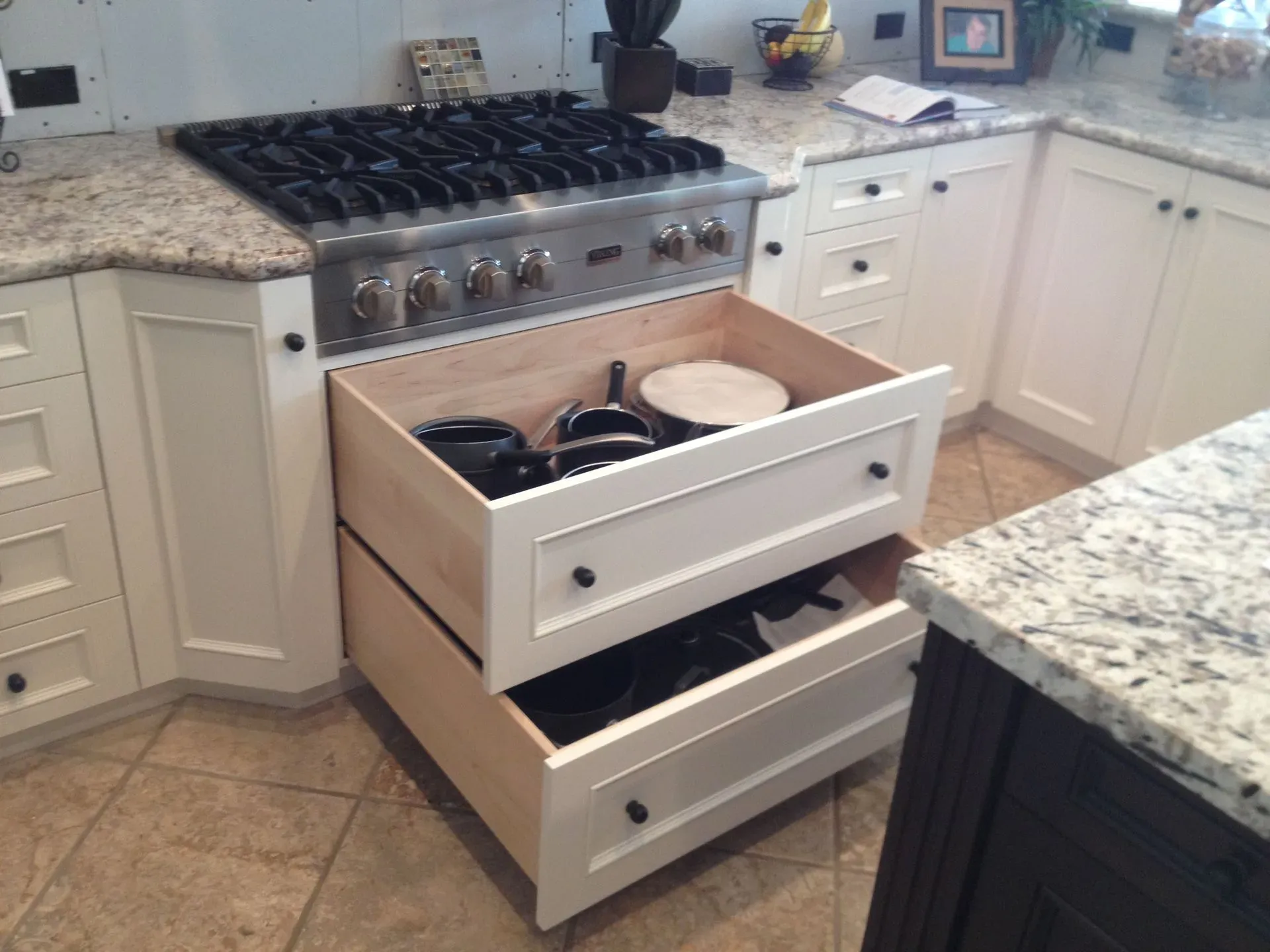 Kitchen stove with open drawers, including a drawer for pots and pans