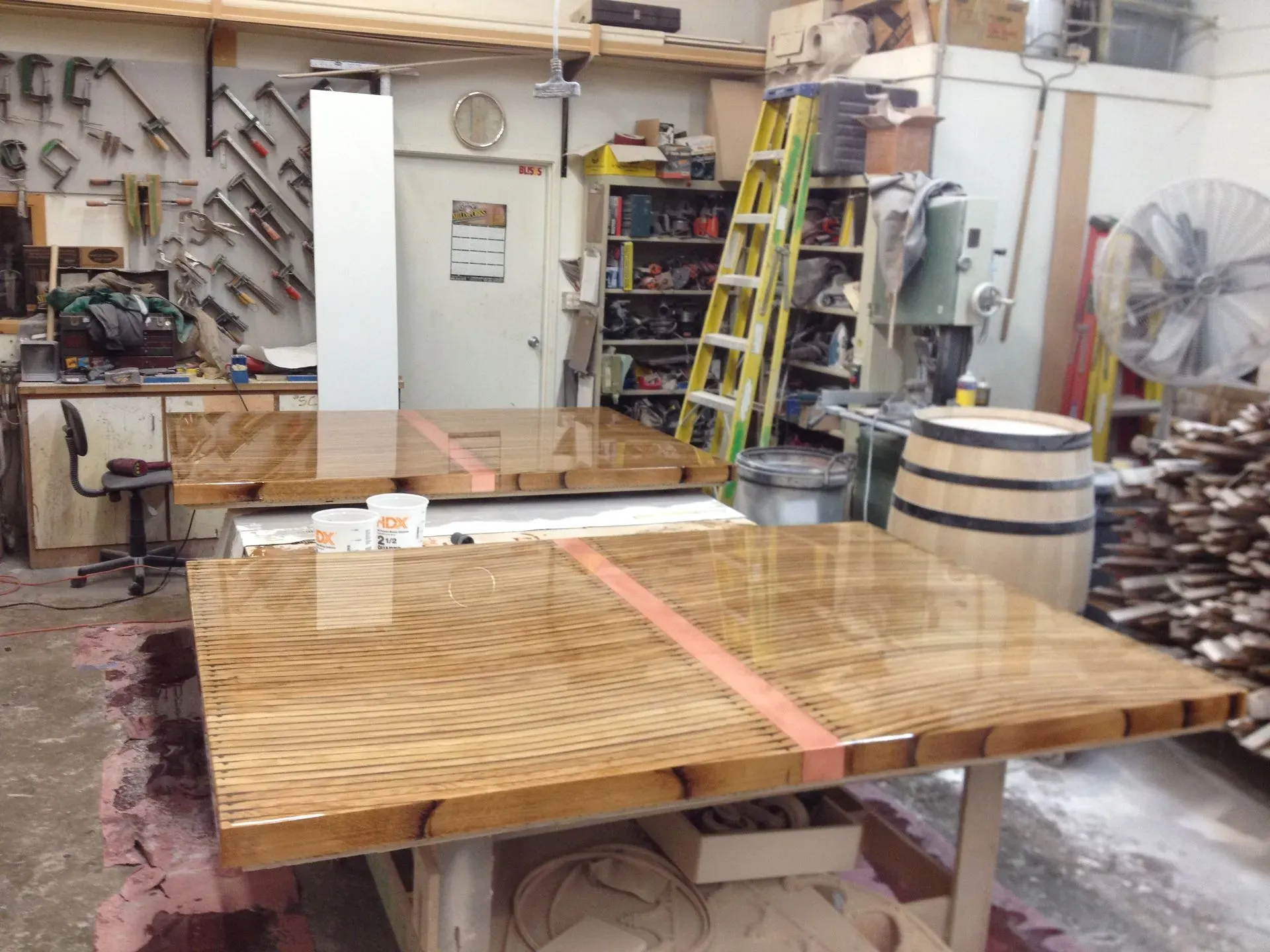 Woodshop with large wooden crate on workbench, tools and ladder in the background