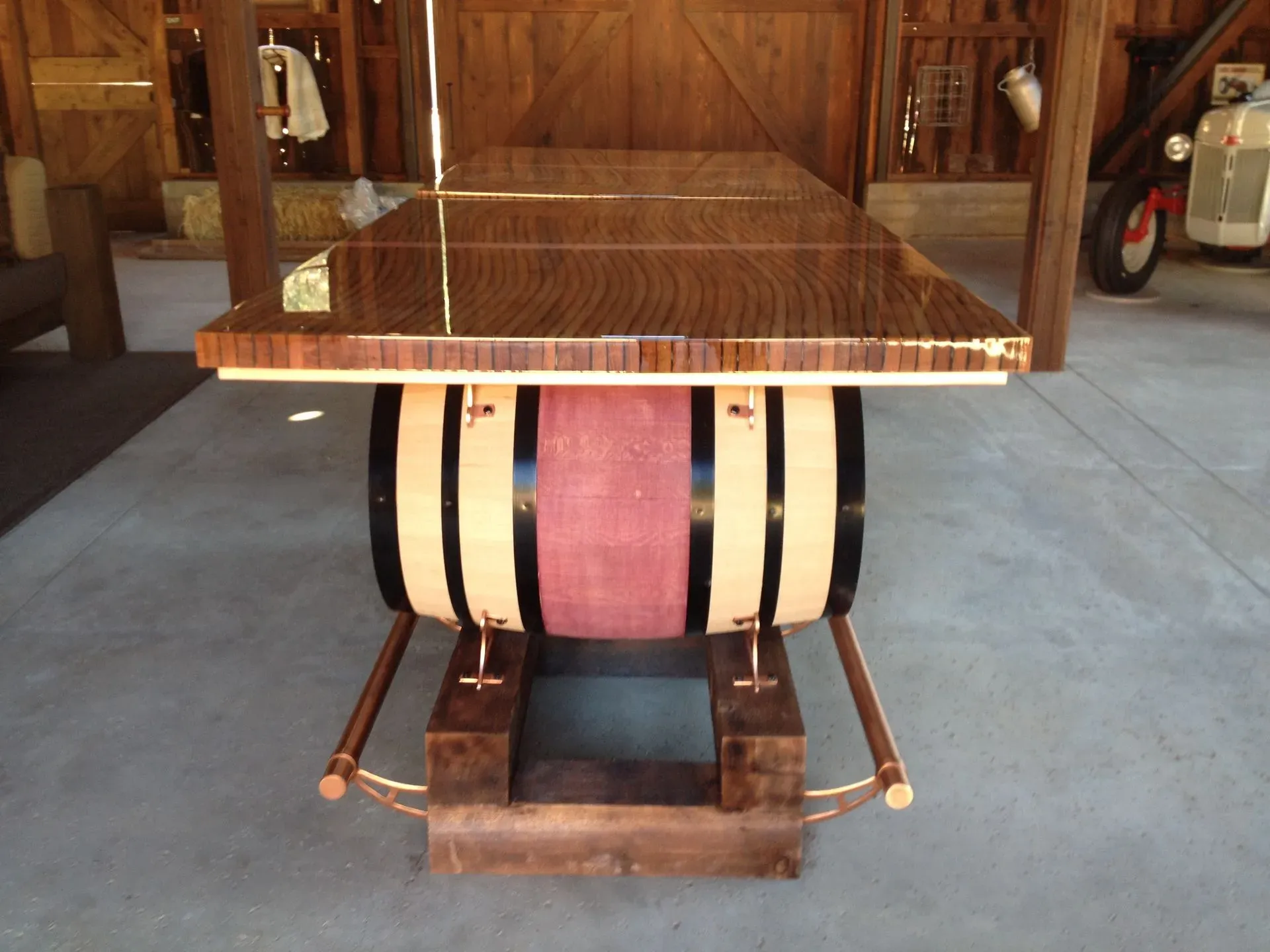 Wooden bar top mounted on a barrel base in a rustic indoor setting