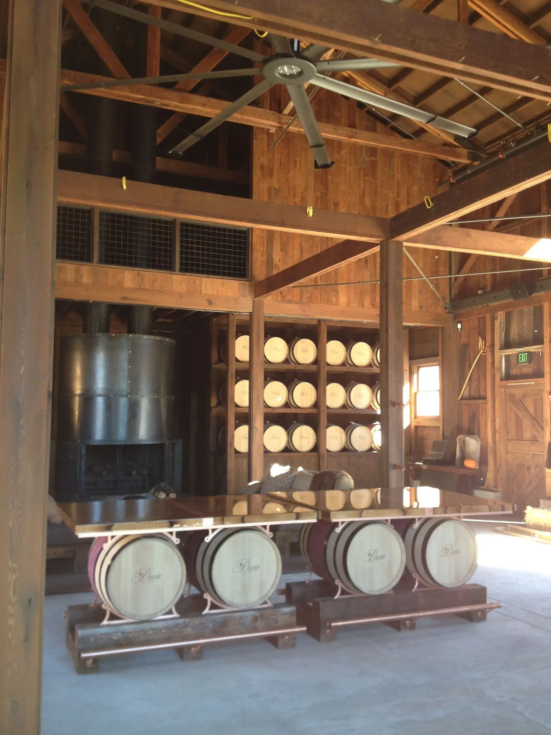 Rustic wine cellar with wooden barrels and stacked casks under exposed beams