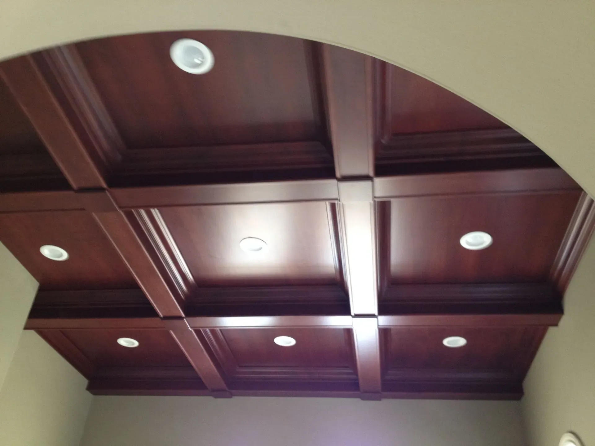 Wood-paneled coffered ceiling with recessed lights and dark wooden beams