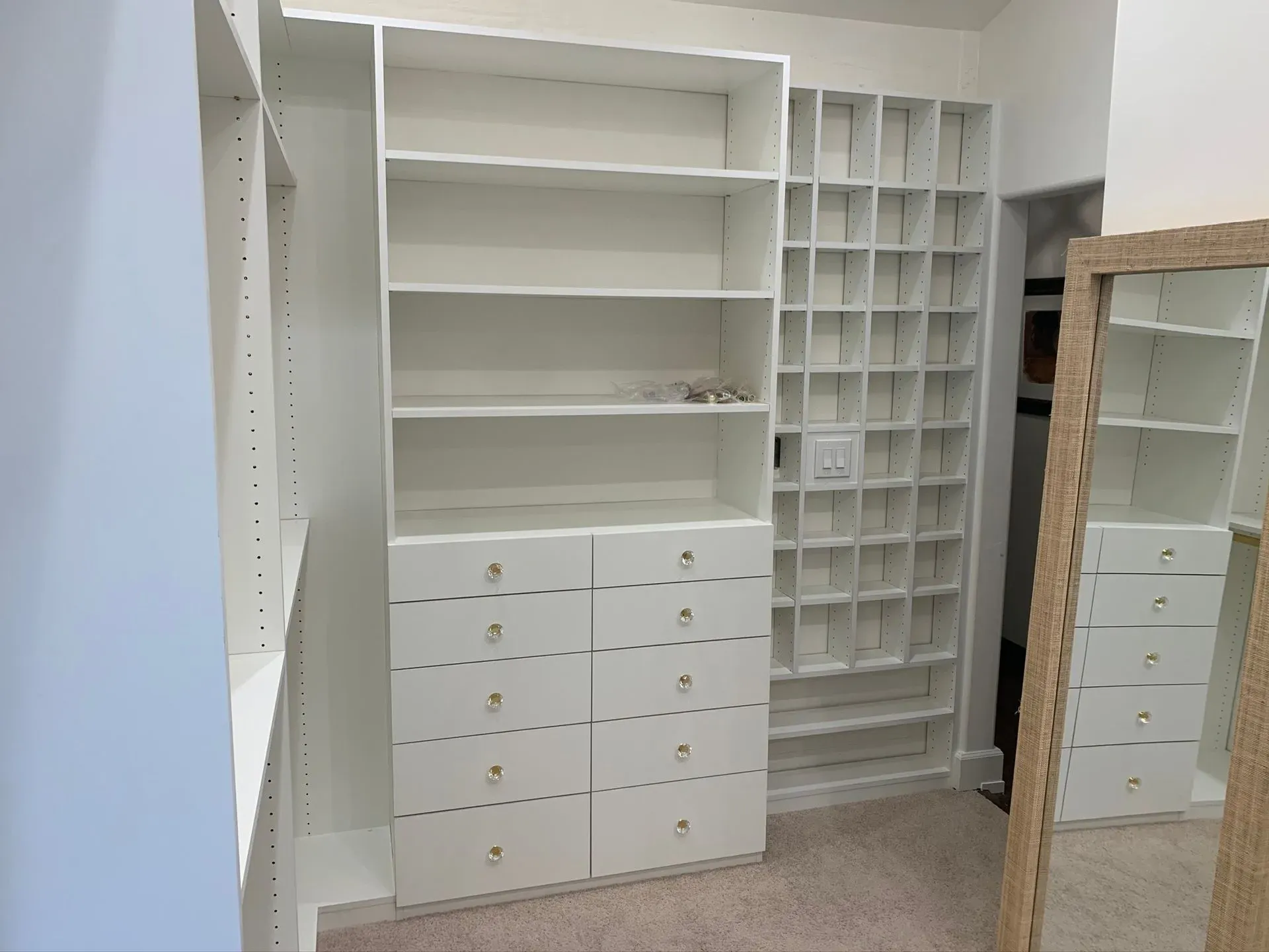 White walk-in closet with shelves, drawers, hanging space, and a mirrored door.