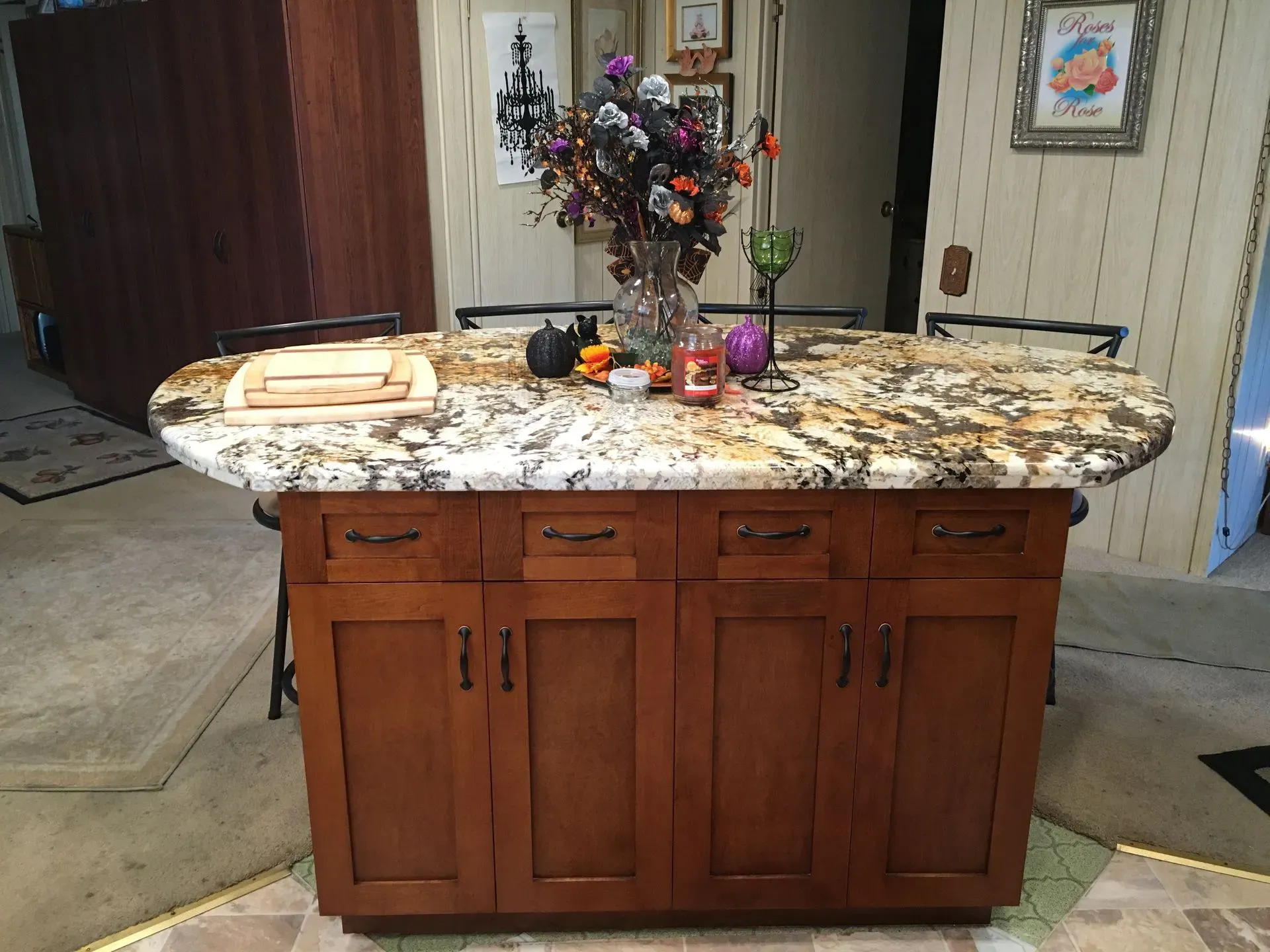 Kitchen island with granite top, flowers, candles, and trays in a garage setting