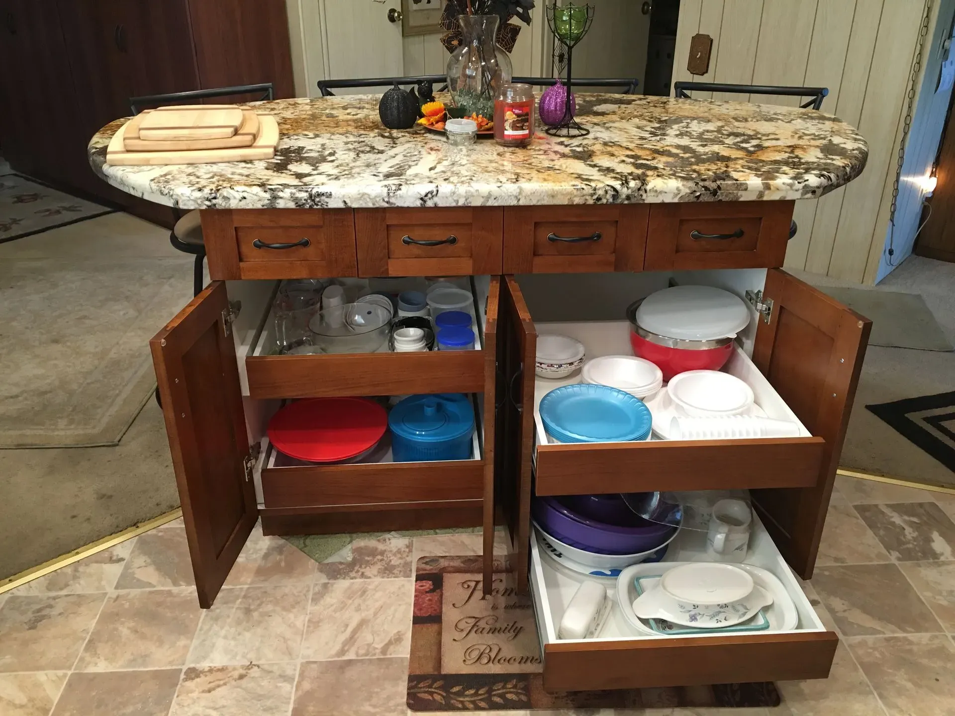 Kitchen island with open cabinets and shelves holding colorful bowls, plates, and dishes