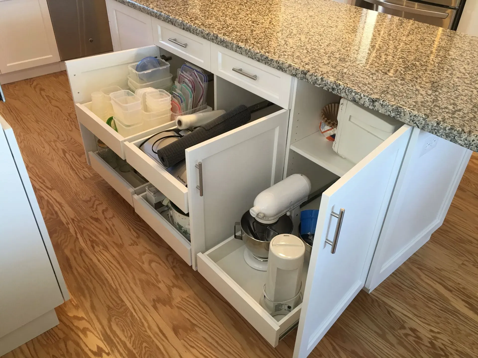 Open under-sink kitchen cabinet with cleaning supplies and a garbage disposal unit exposed