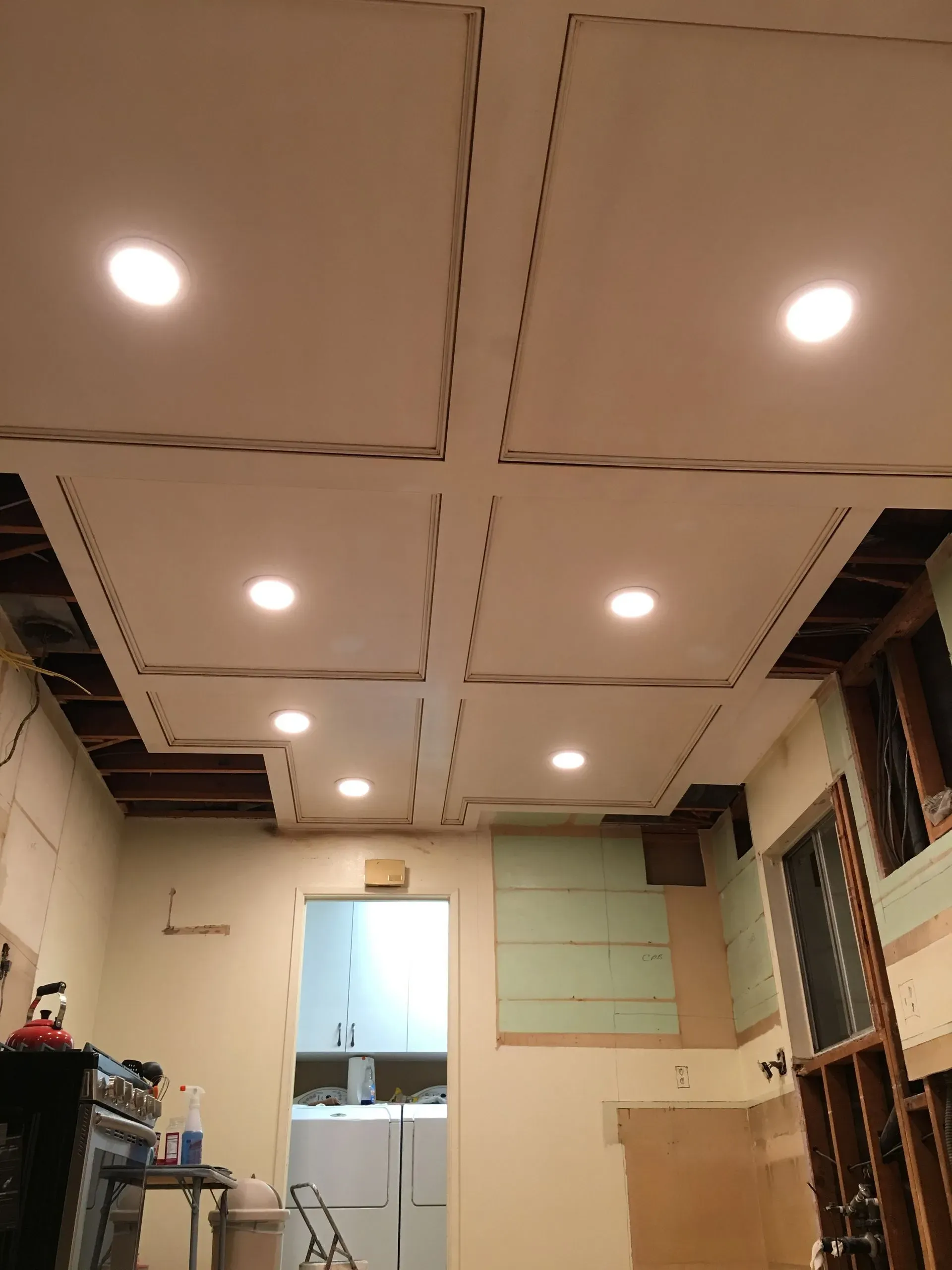 Partially finished room with recessed ceiling lights, exposed framing, and an open doorway at the back