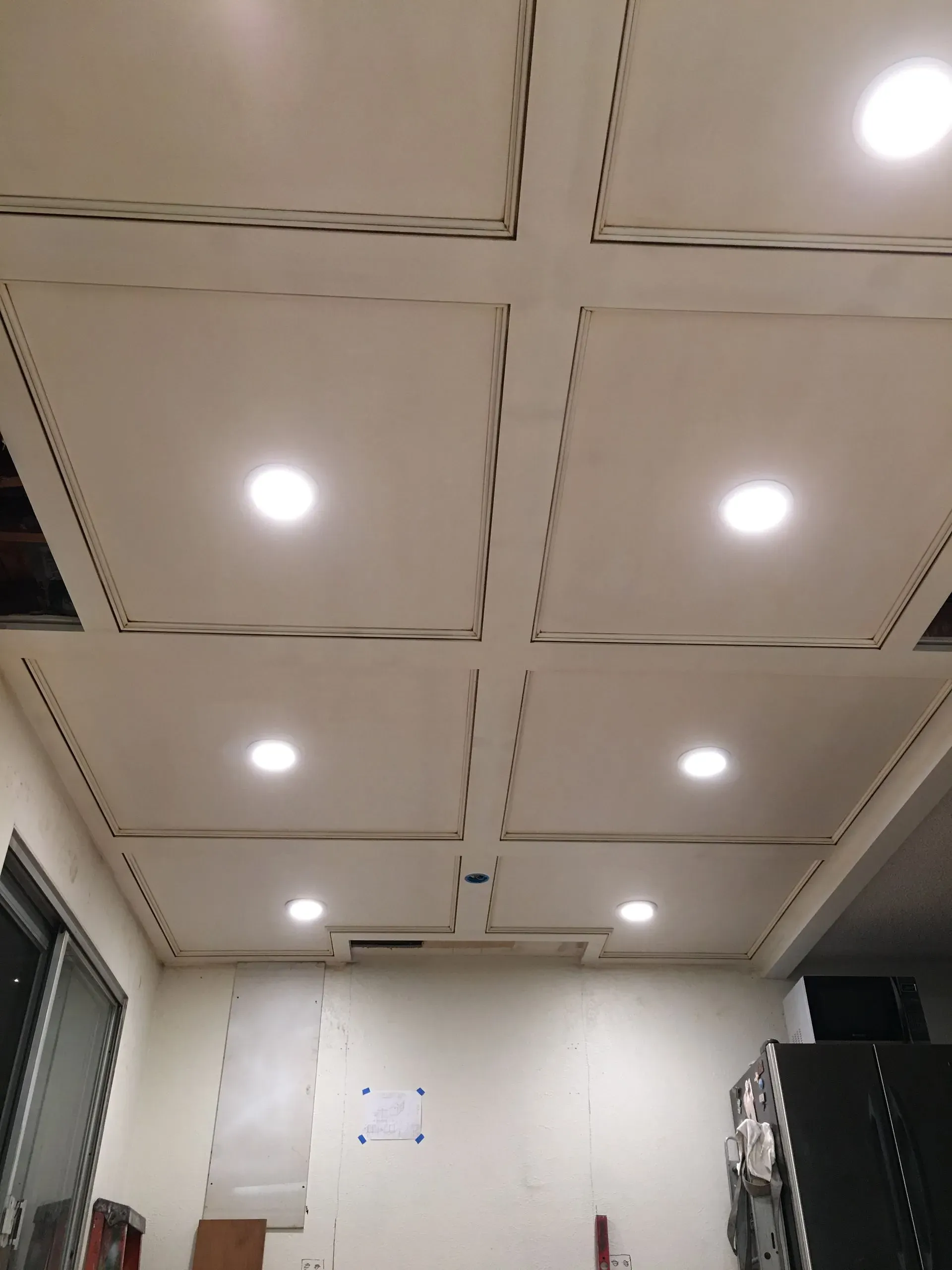 Ceiling with recessed lights in a room, viewed upward from below.
