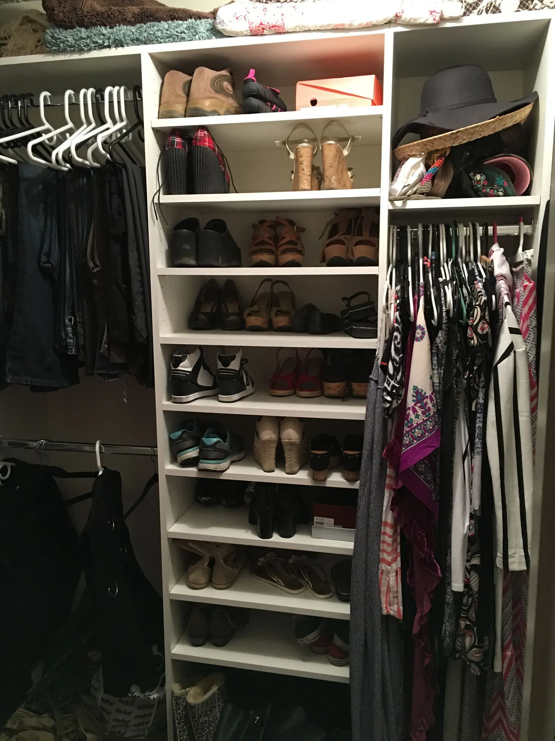 Walk-in closet with shoes, hanging clothes, shelves, and hats neatly arranged.