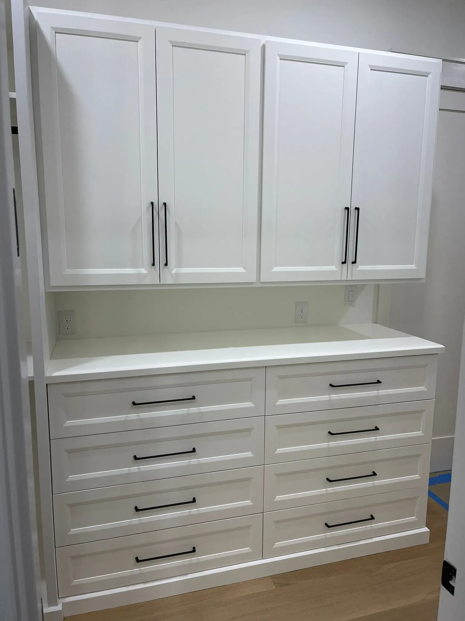 White wall cabinet and drawer storage unit with countertop in a room
