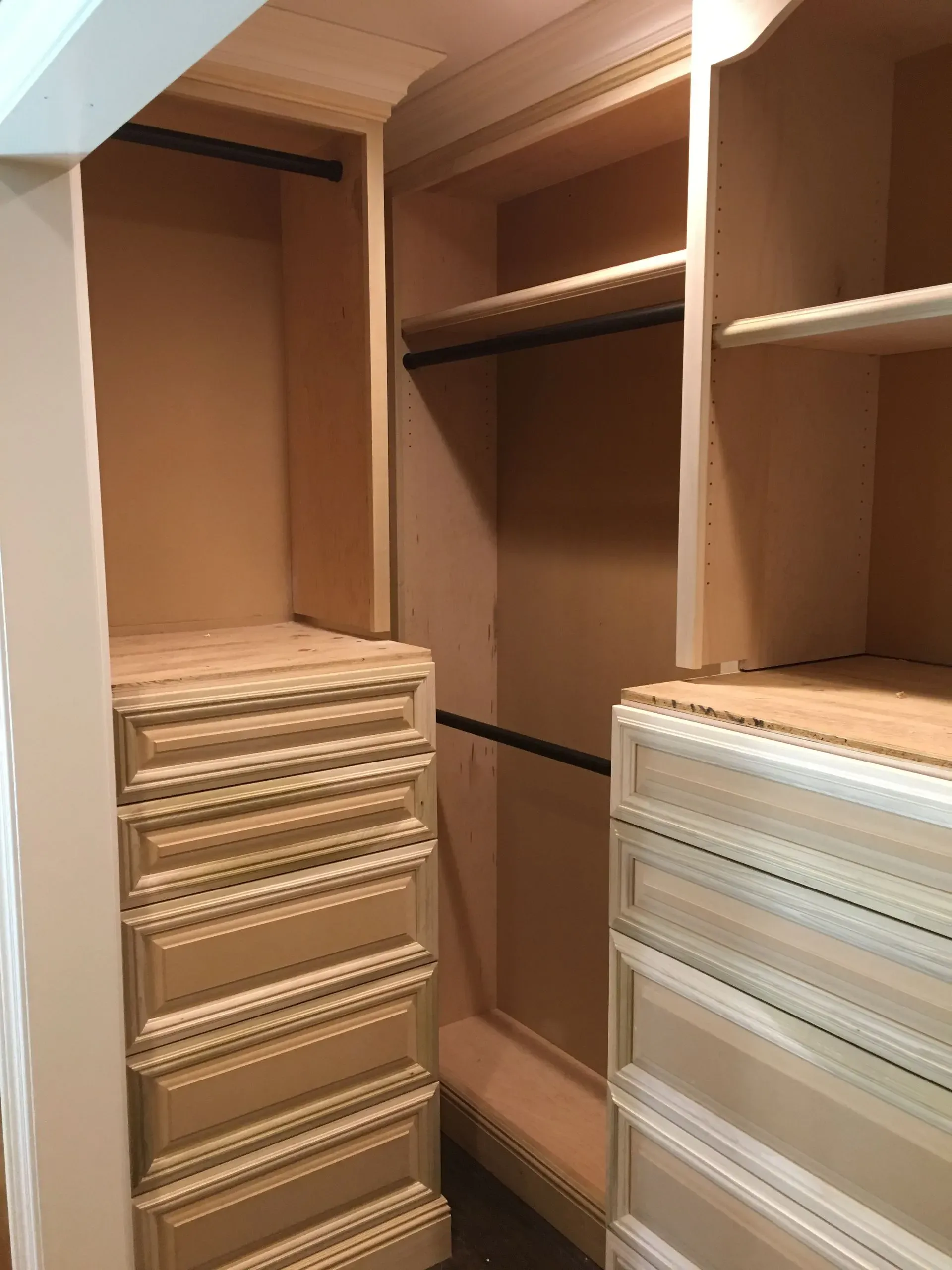 Open closet with wooden shelves and woven storage drawers in beige and white