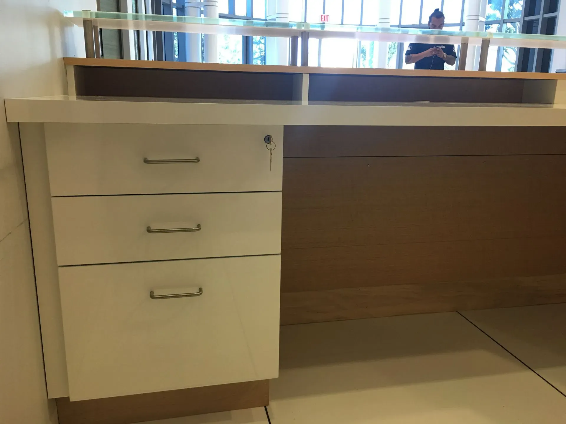 Office desk with three drawers and a wooden work surface by a window