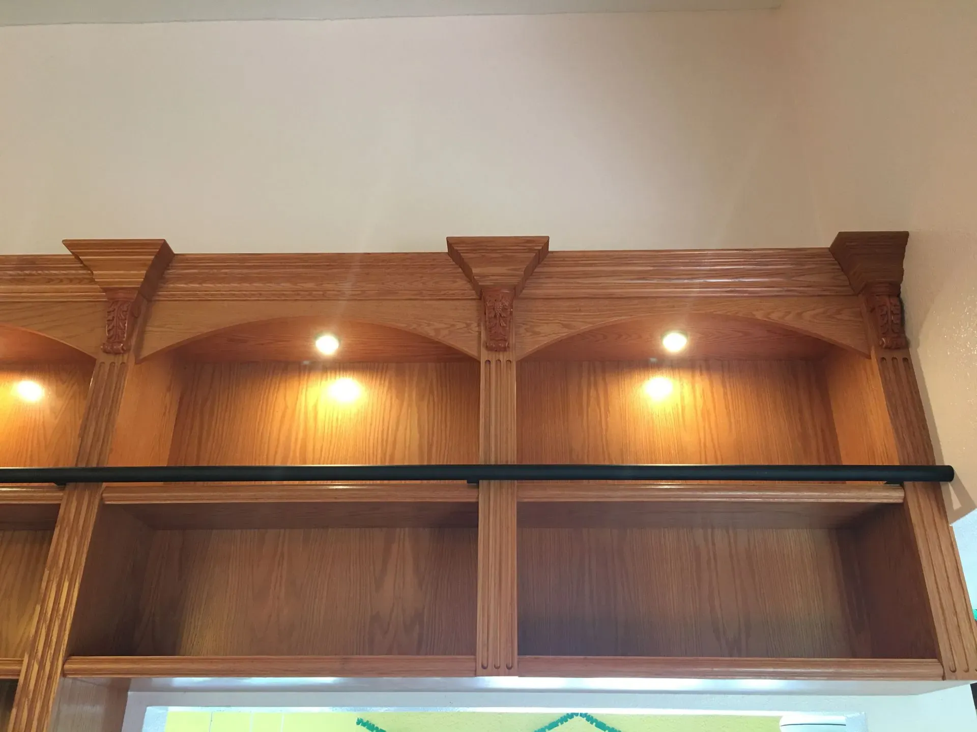 Wood-paneled wall with built-in shelves and warm recessed lighting in a room