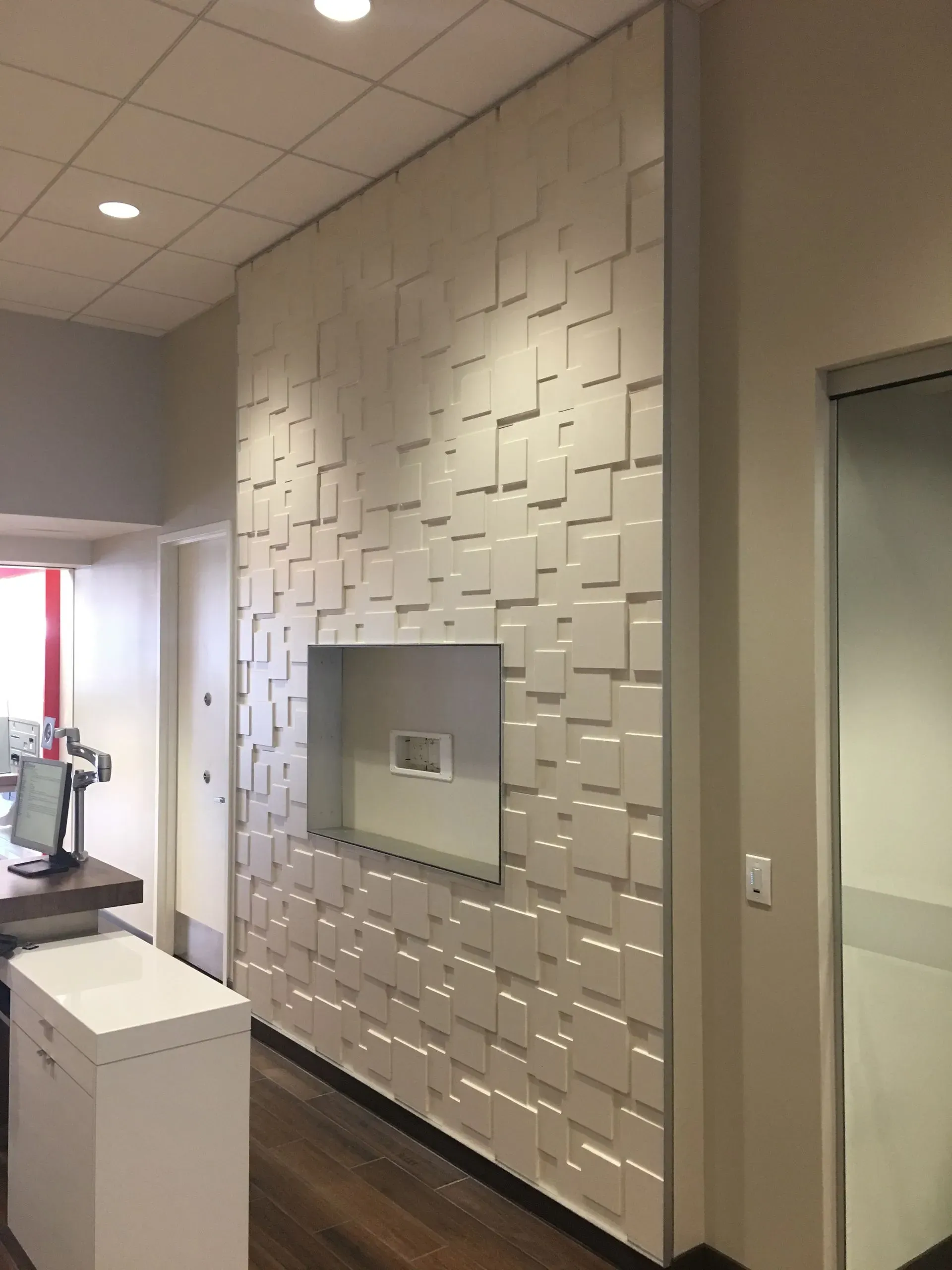 Modern office interior with textured white accent wall and built-in recessed display niche